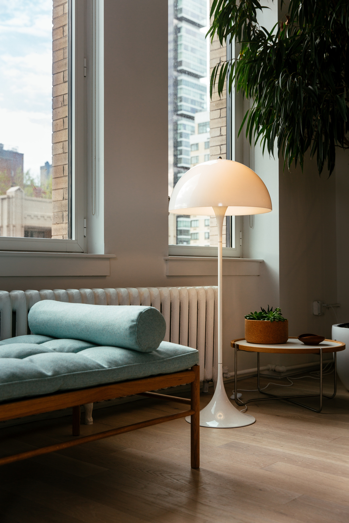 Weiße Panthella Stehleuchte von Louis Poulsen im Wohnzimmer neben einer Couch und einem Beistelltisch.