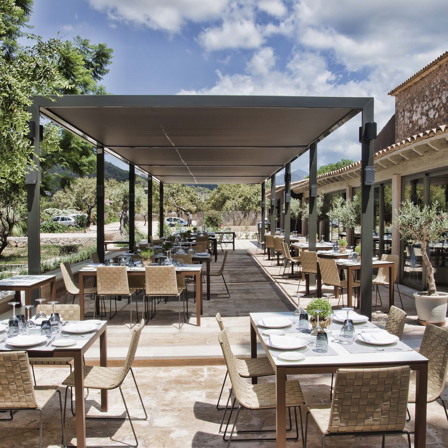 Außenbereich eines Restaurants mit Tischen und Trenza Stühlen von Andreu World, stapelbare Outdoor-Stühle.