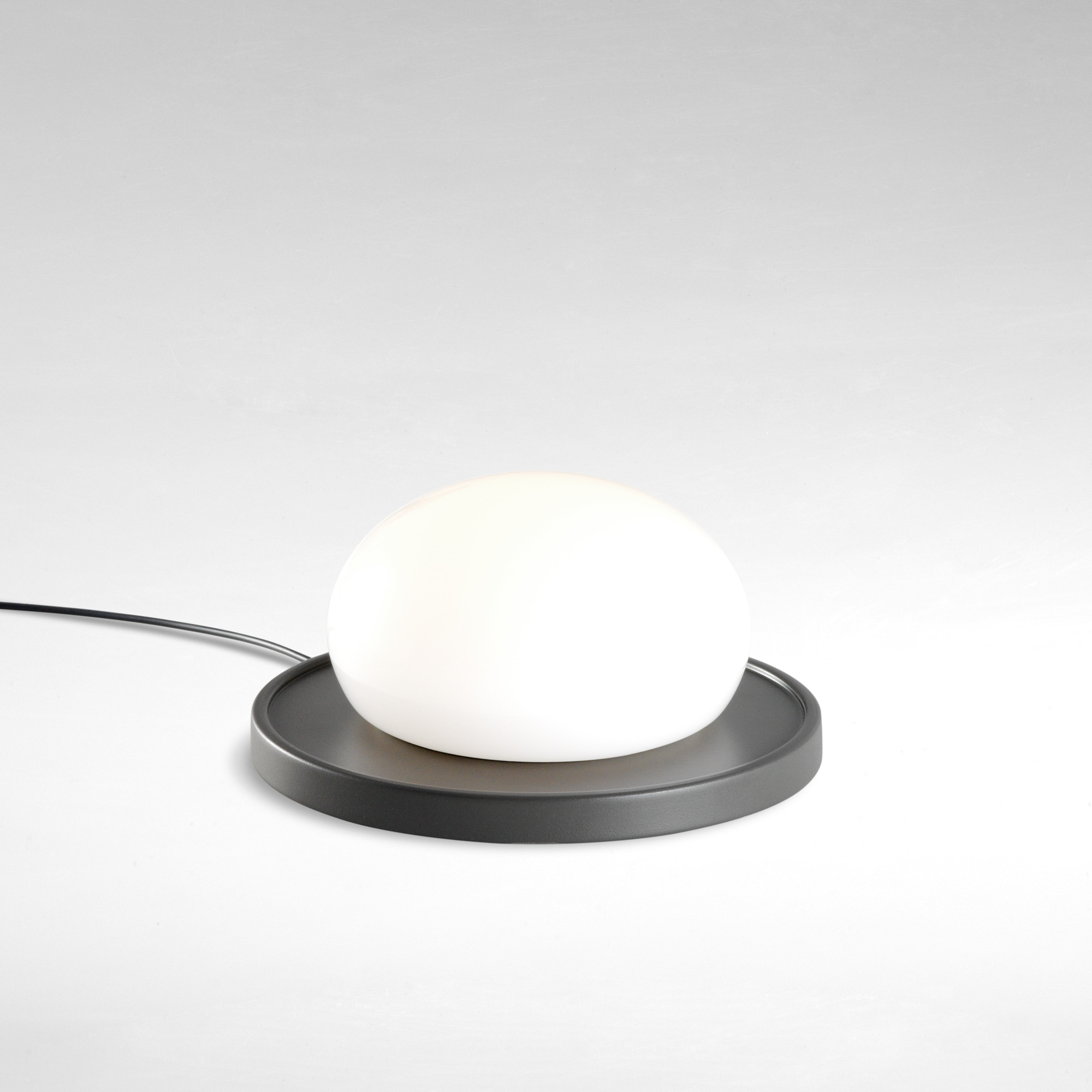 Weiße Bolita Tischleuchte von Marset: Runde LED Lampe mit grauem Sockel für Nachttisch oder Schreibtisch.