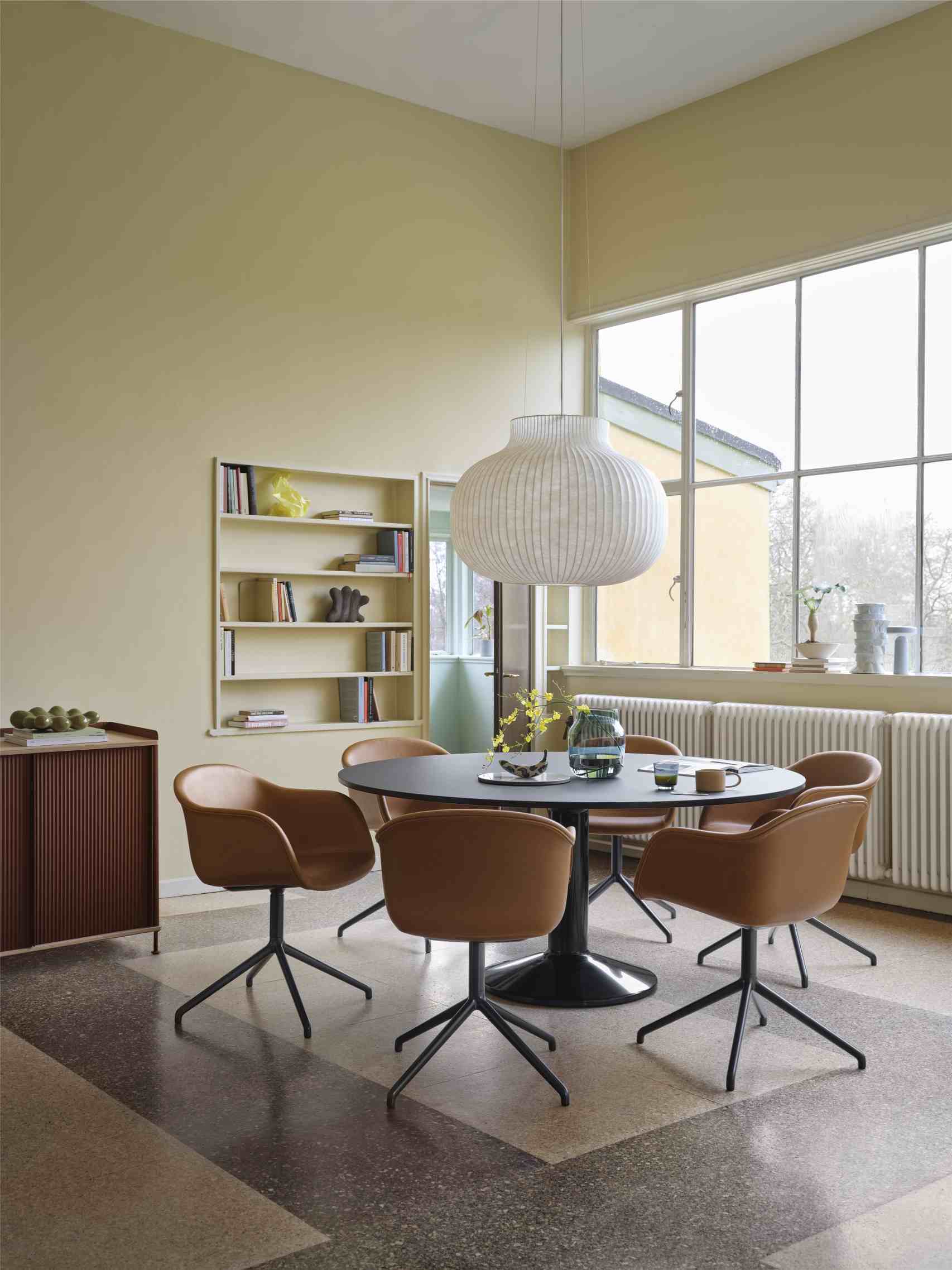MIDST Table von Muuto: Runder Esstisch mit braunen Stühlen in einem hellen Esszimmer.