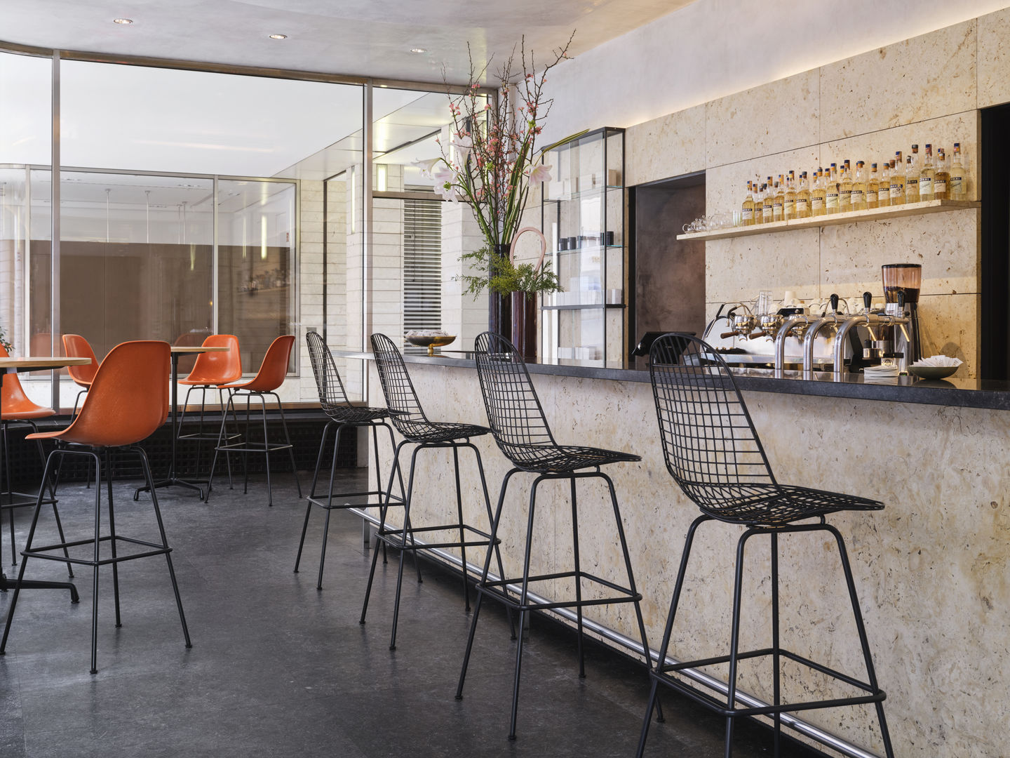 Eames Wire Bar Stool von Vitra in einer Bar, schwarzes Drahtgestell, hoher Hocker.