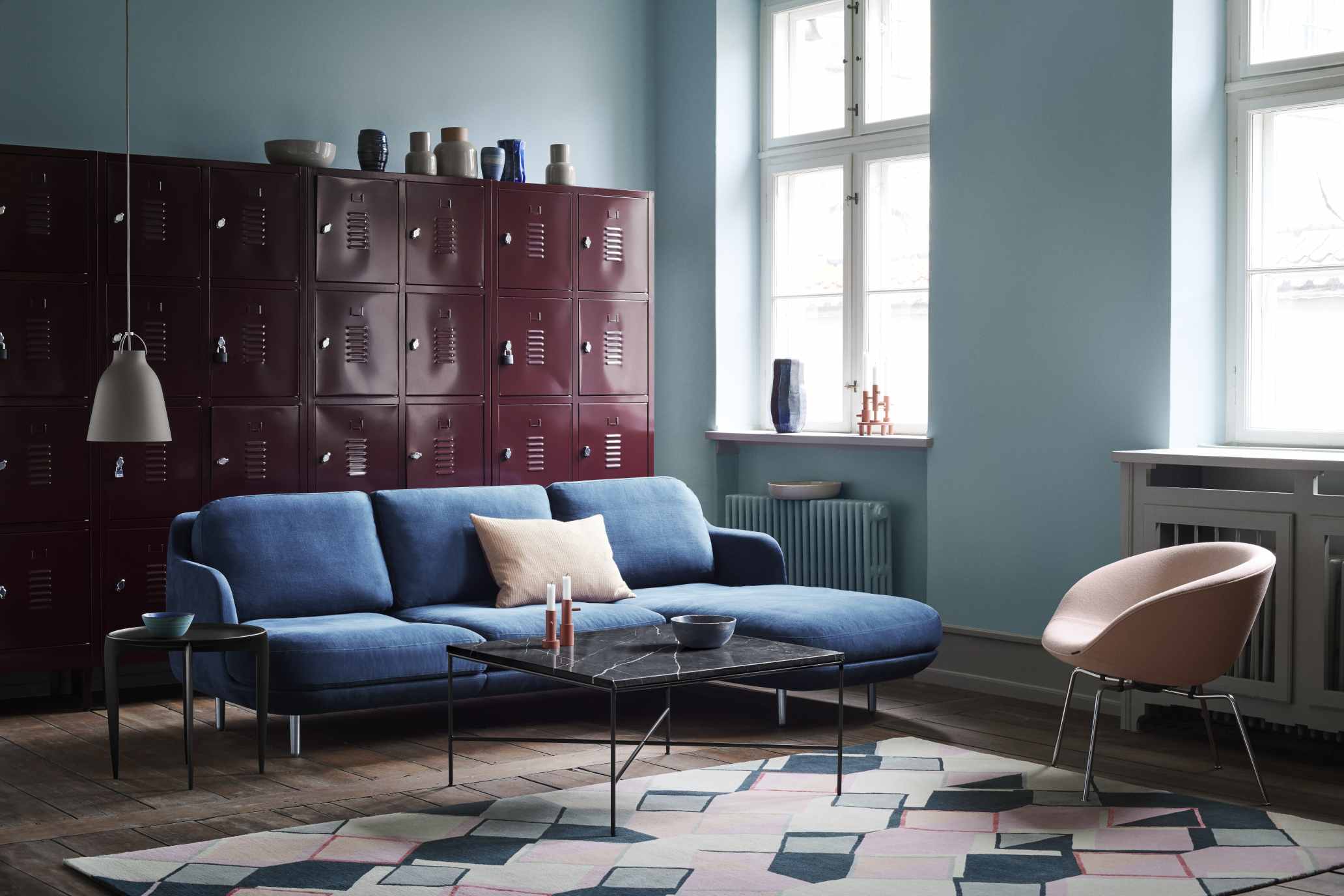 Wohnzimmer Interieur mit blauem Sofa, Marmor Couchtisch und einem hellrosa Pot Sessel von Fritz Hansen.