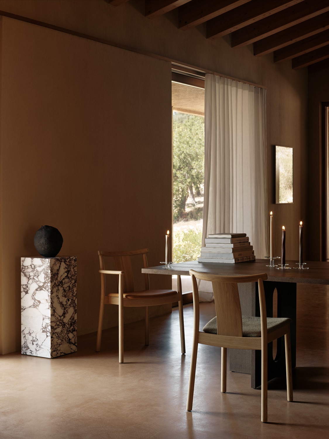Audo Copenhagen Merkur Dining Chair Stuhl mit Armlehnen in einem modern eingerichteten Esszimmer.