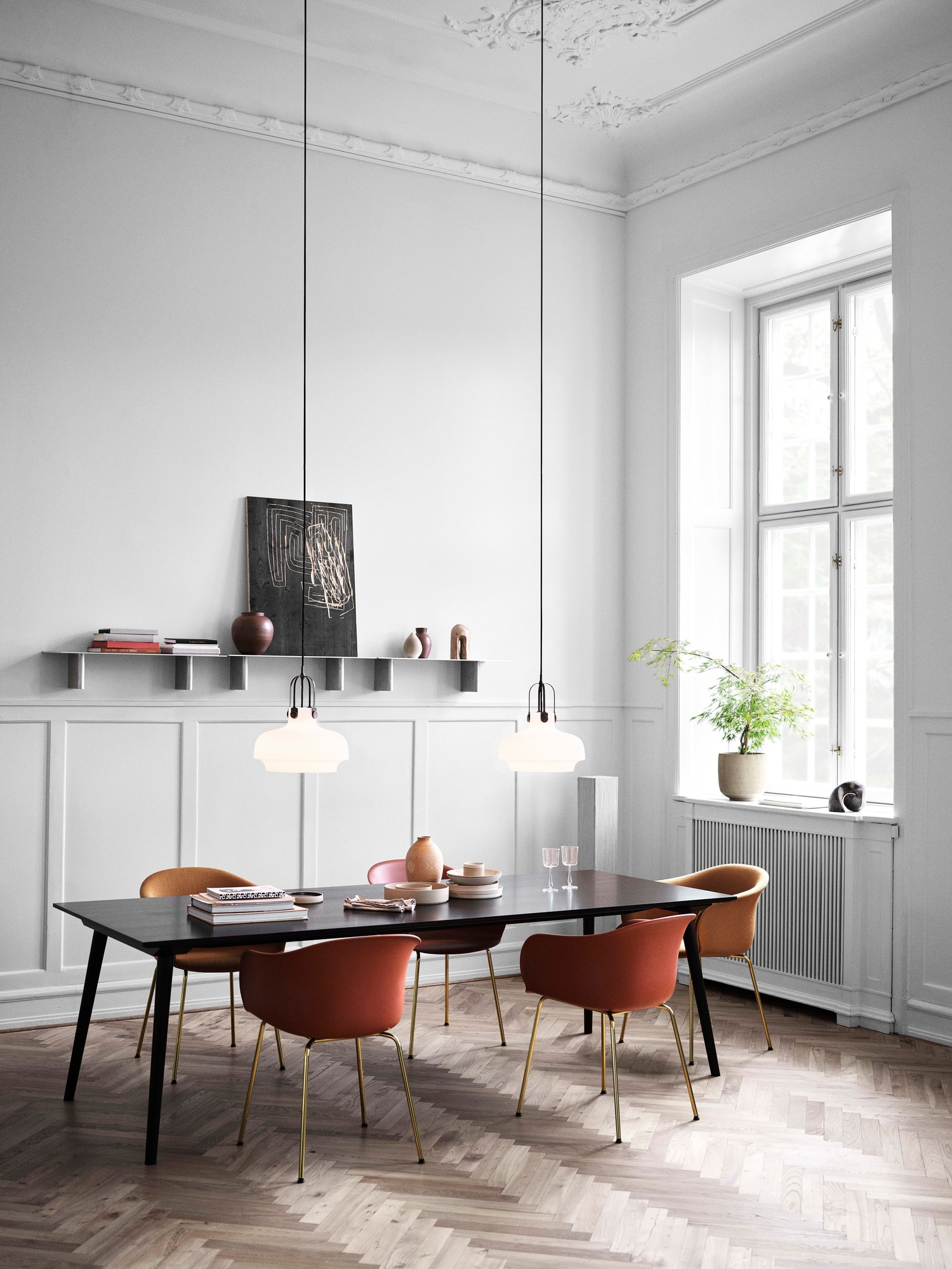 Esszimmer mit Copenhagen SC7 Pendelleuchten von AndTradition über einem Esstisch mit Stühlen.