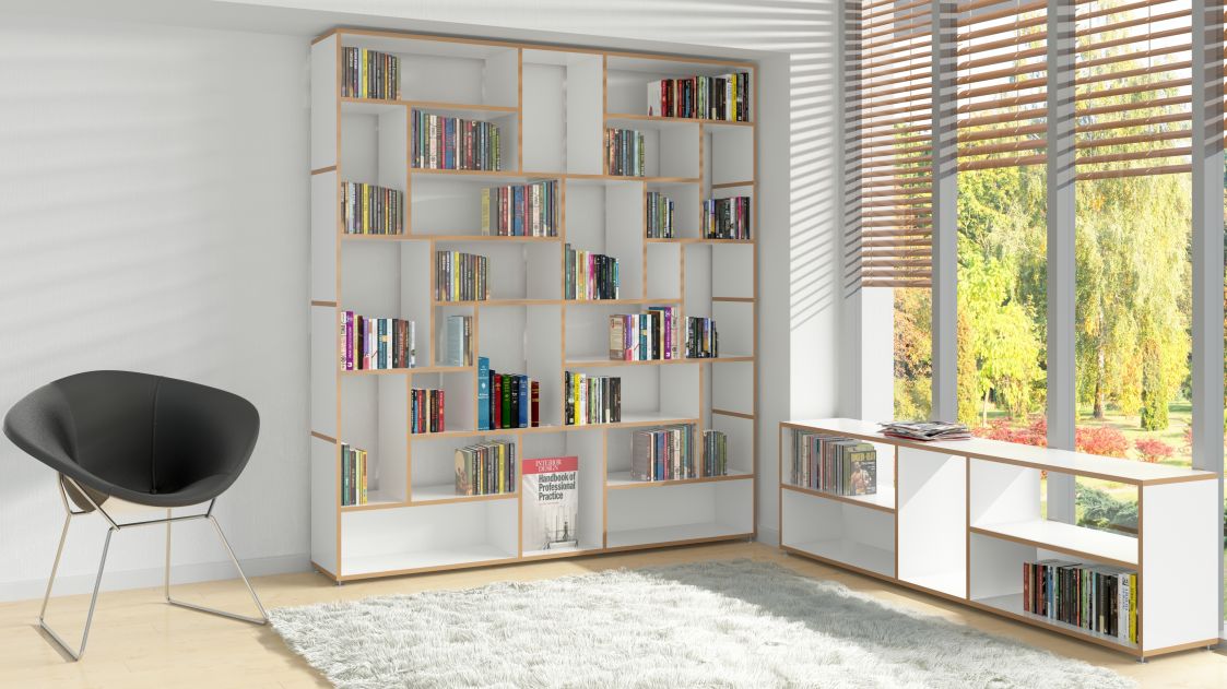 Modernes Bücherregal in Weiß und Holz mit Büchern, Sessel und Teppich im Wohnzimmer.