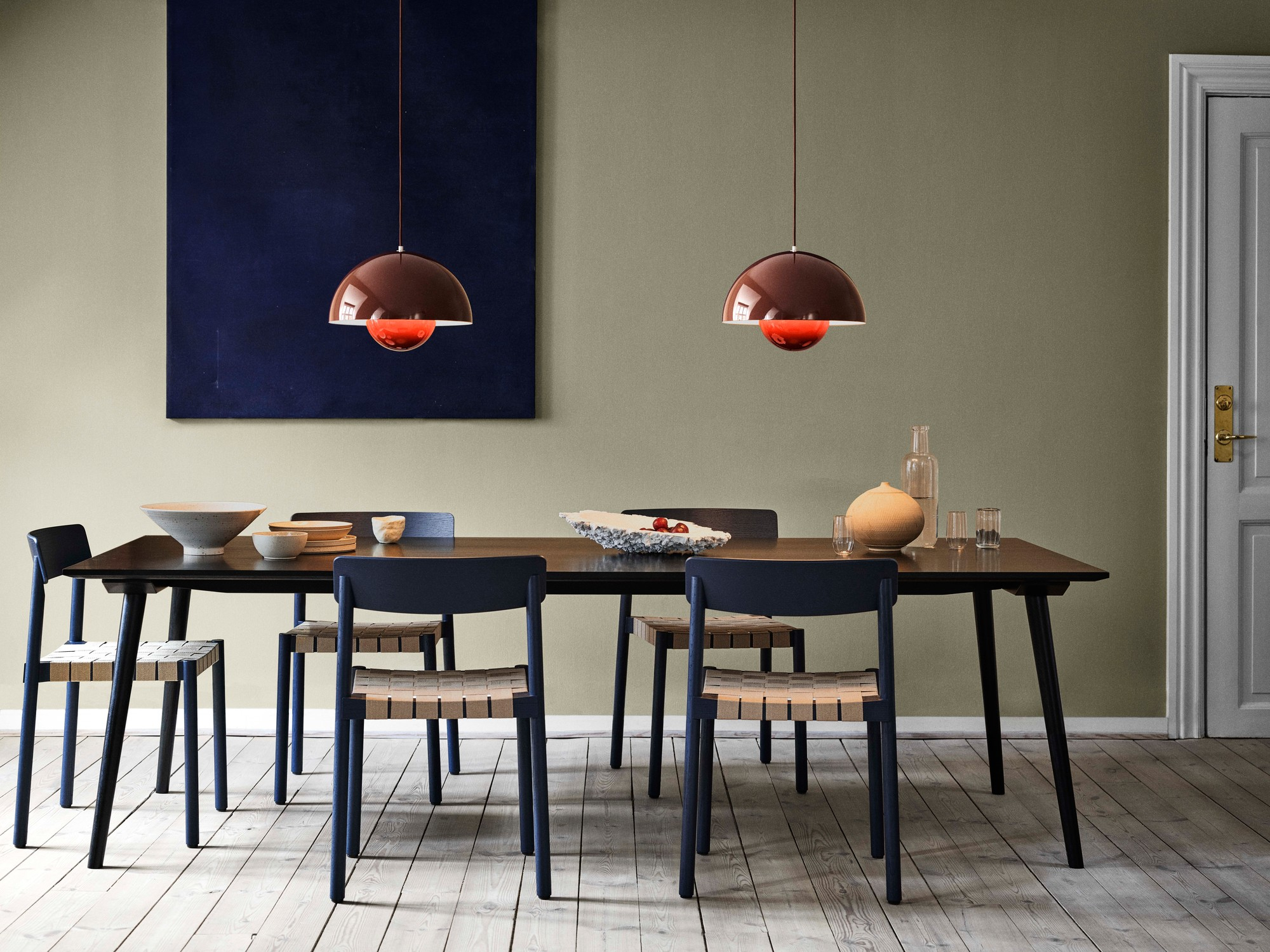 Esszimmer mit zwei Flowerpot Pendelleuchten von AndTradition in Kupfer über einem Esstisch.