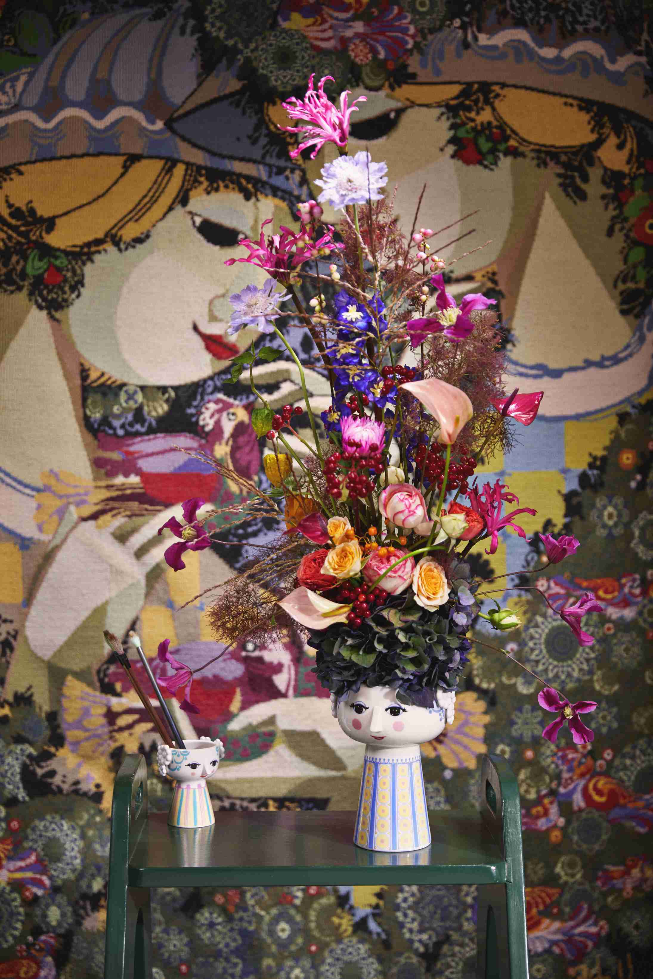 Blumenarrangement in Keramikvase mit Gesicht, bunte Blumen, dekorativ, für Wohnzimmer und als Geschenkidee.