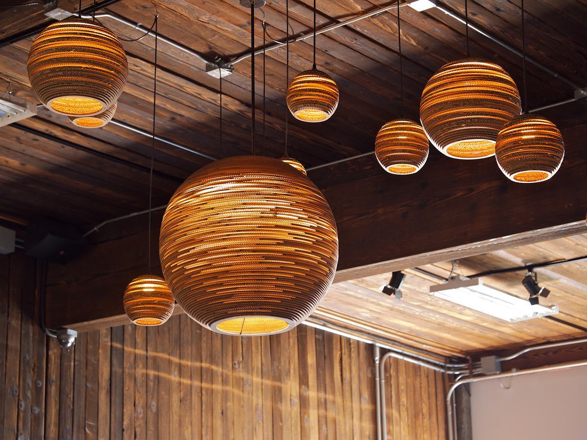 Mehrere Moon18 Scraplights Hängeleuchten von Graypants aus recycelter Pappe in einem Raum.