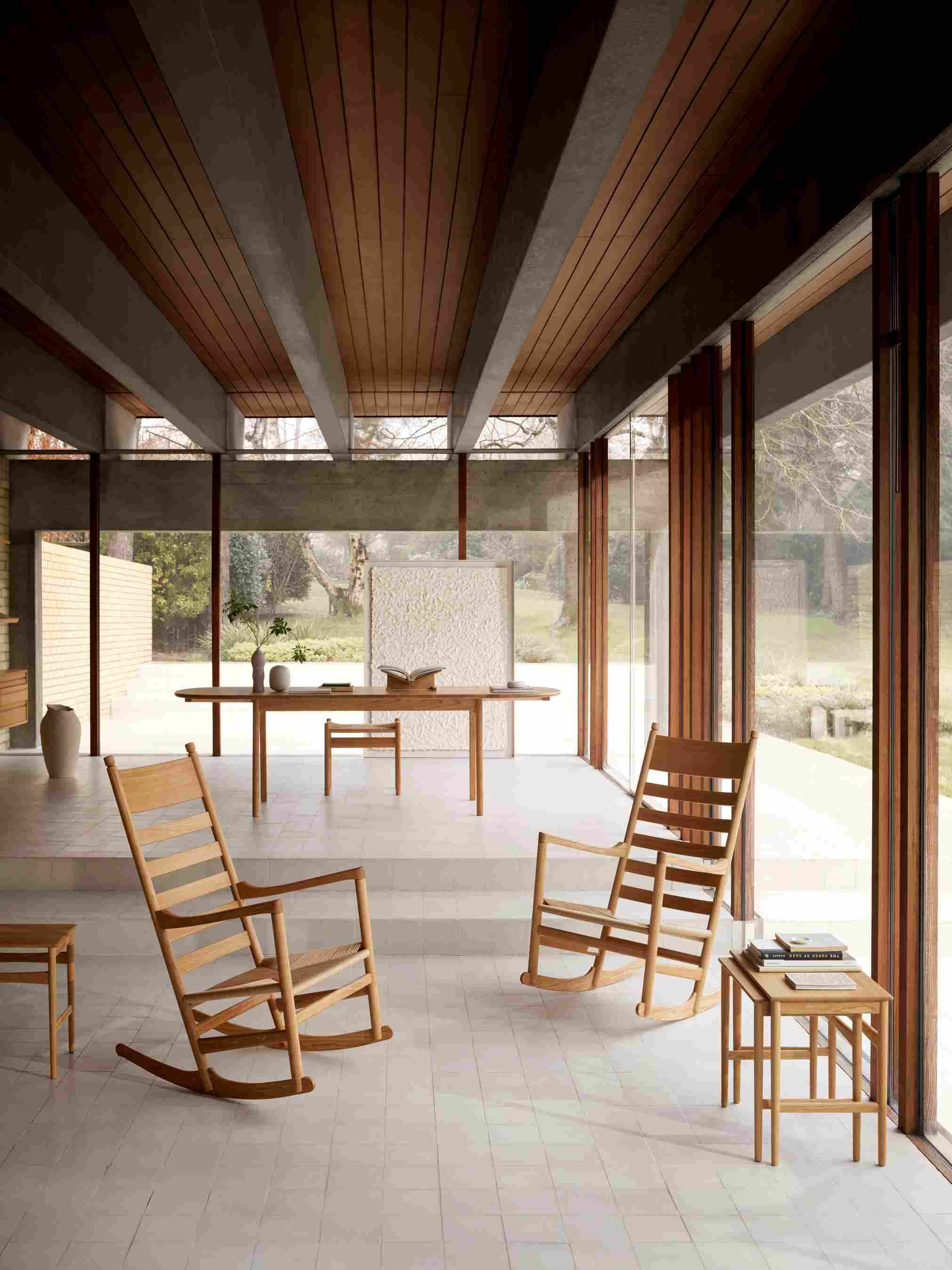 Helle, moderne Inneneinrichtung mit zwei Holzschaukelstühlen, Esstisch und Beistelltisch. Skandinavisches Design.