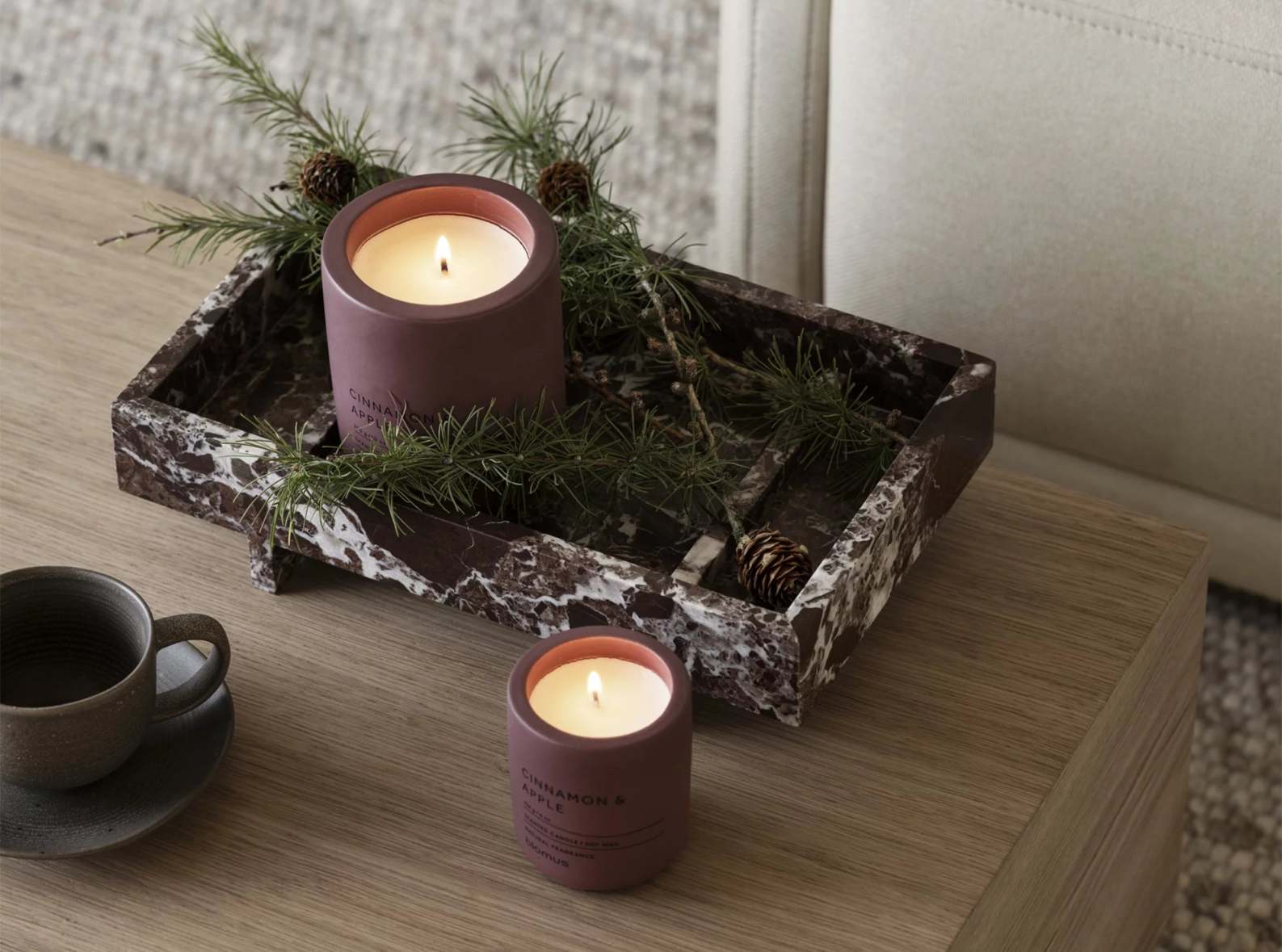 Abento Marmor Tablett mit Kerzen und Tannenzweigen als Dekoration auf einem Holztisch.