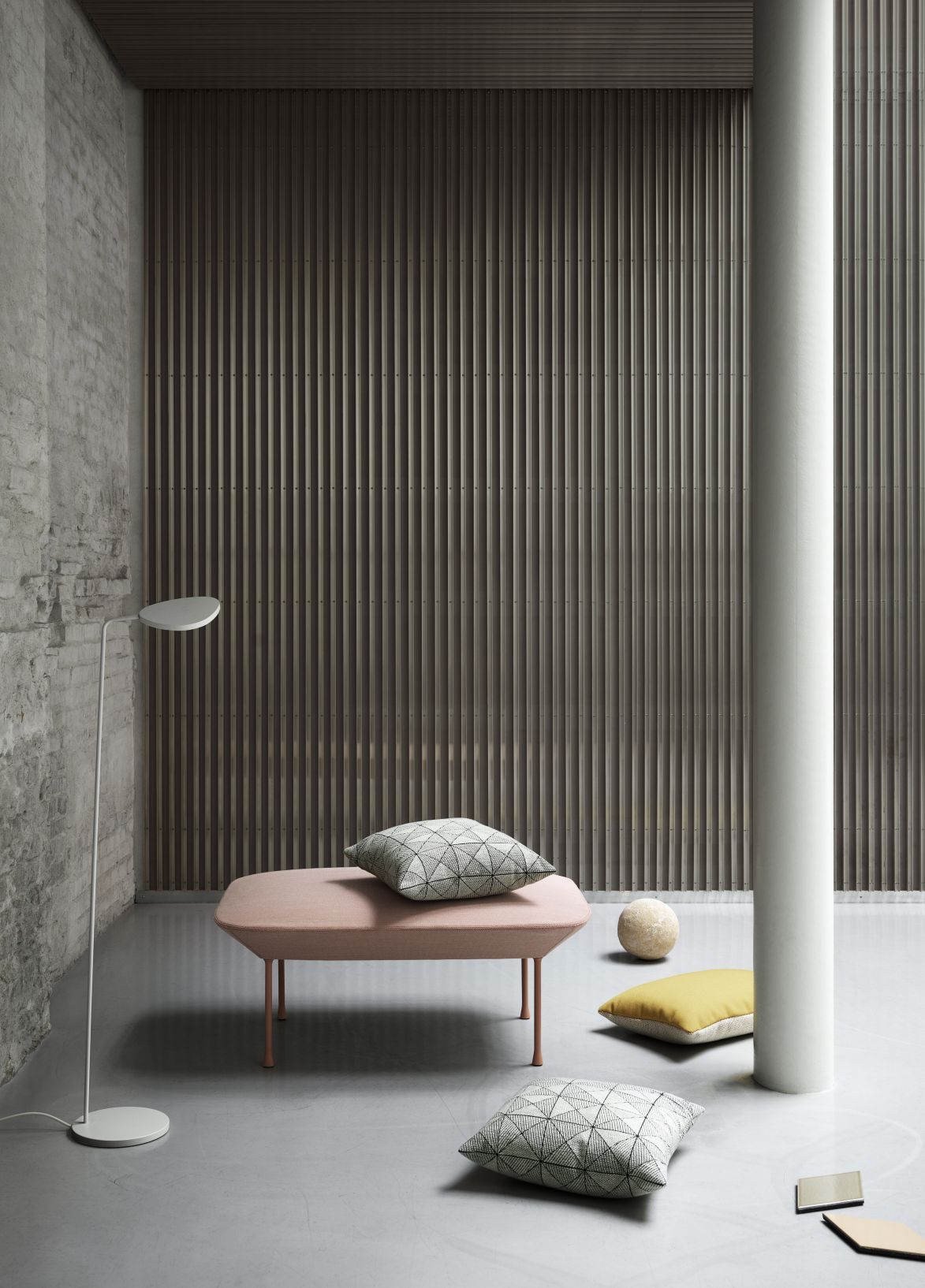 Muuto Tile Cushion Kissen 45x45 cm mit geometrischem Muster auf rosa Bank und Boden.