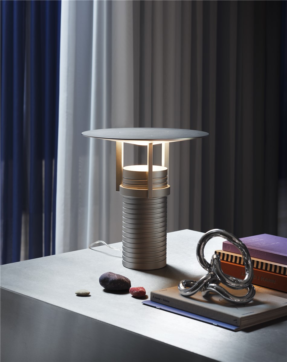 Silberne Muuto Set Table Lamp Tischleuchte auf einem Tisch mit Deko-Elementen.