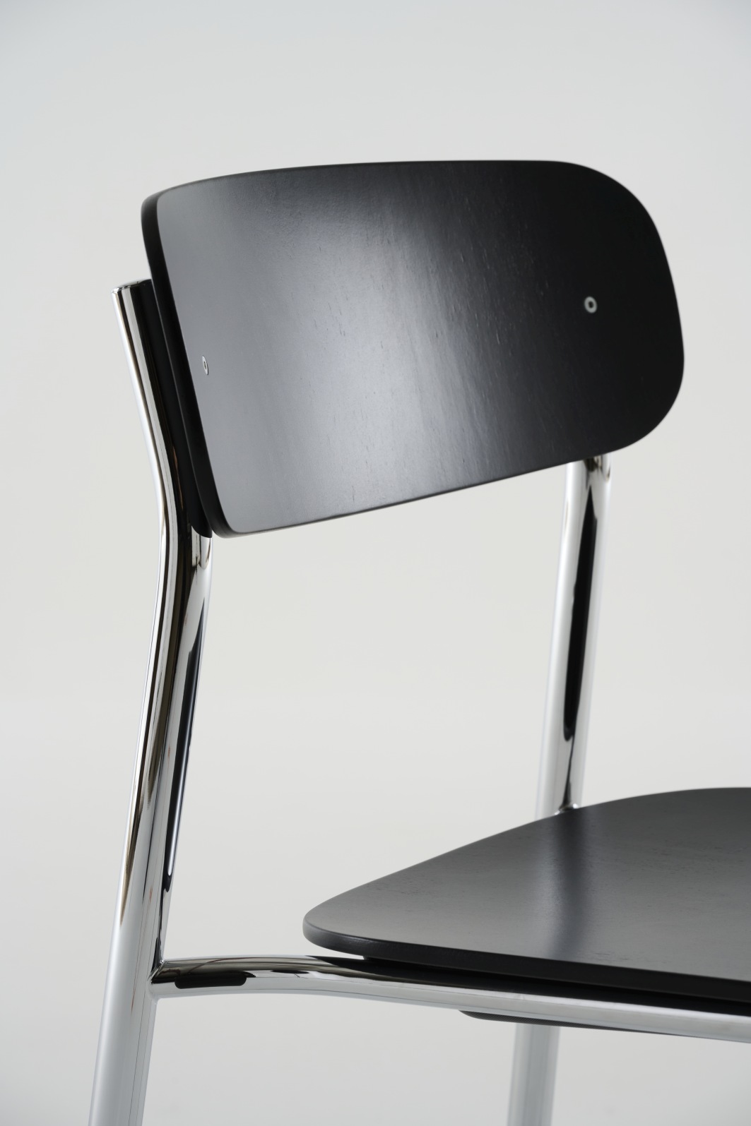 Detailaufnahme des S 243 Stahlrohrstuhls von Thonet mit schwarzer Sitzfläche und verchromtem Gestell.