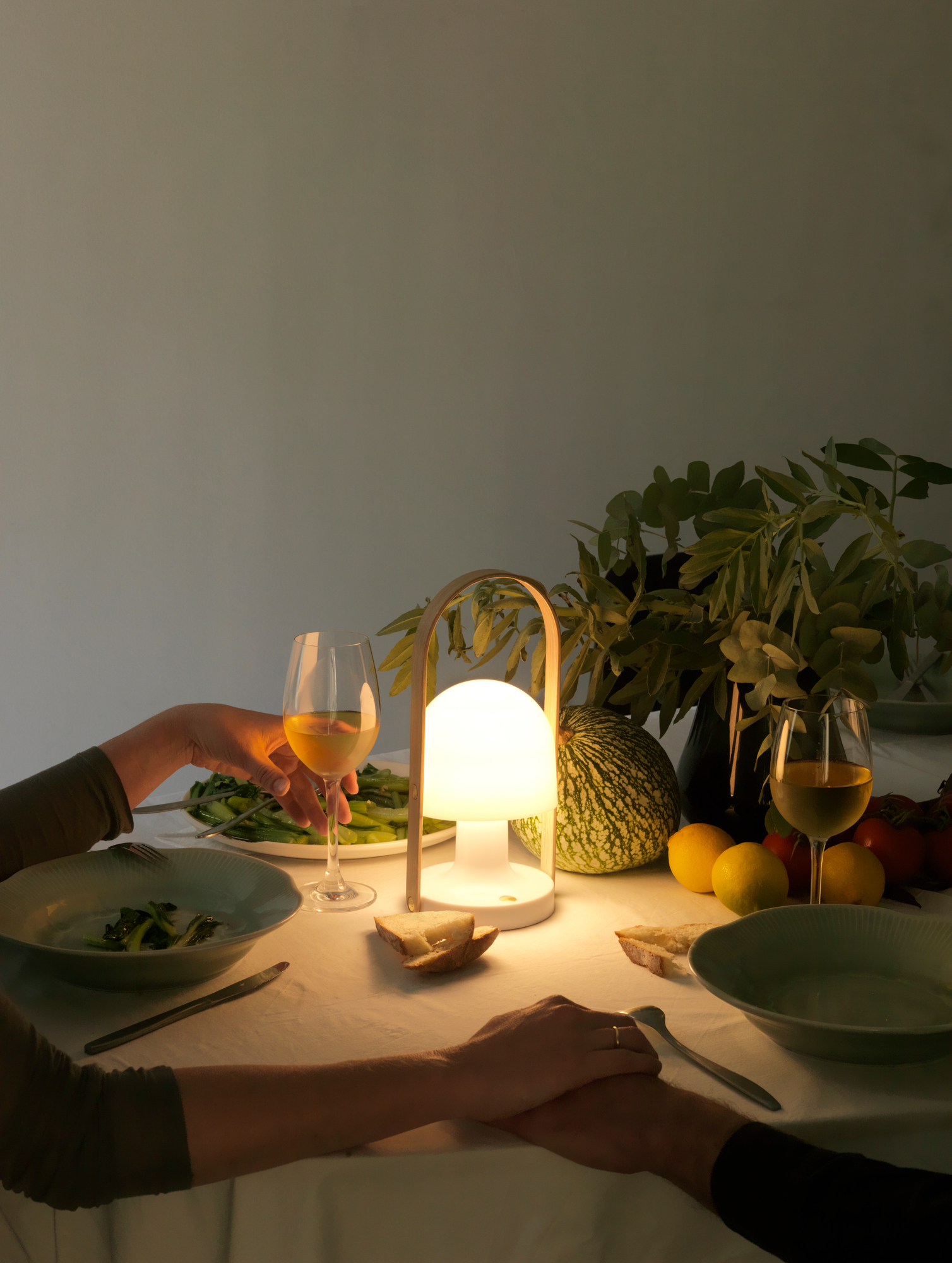 FollowMe LED Tischleuchte in Terrakotta beleuchtet romantisches Abendessen mit Wein und saisonalen Zutaten.