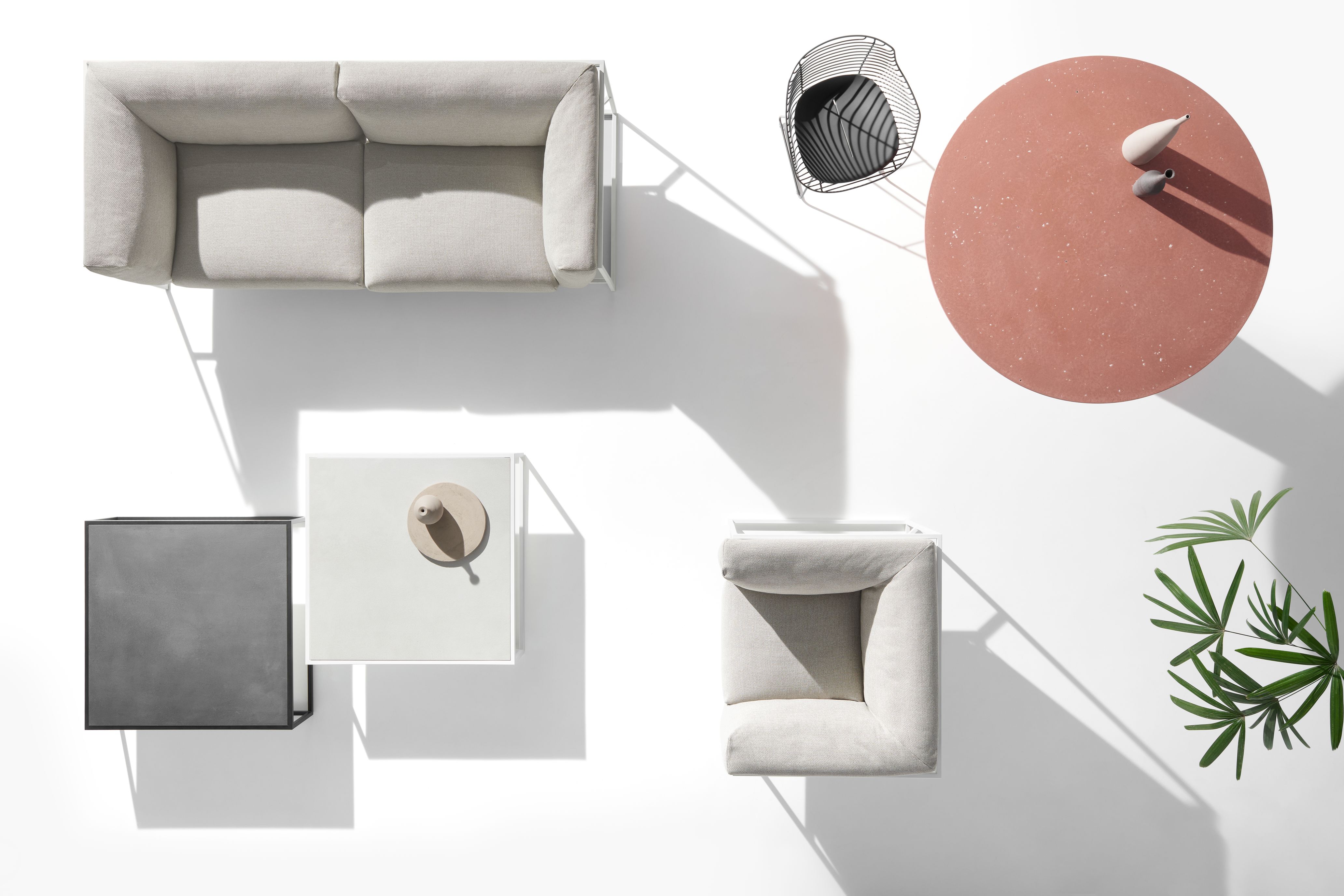 Draufsicht auf ein modernes Outdoor-Wohnzimmer-Set mit Arpa Sofa, Sessel, Beistelltischen und Dekoration auf weißem Hintergrund.