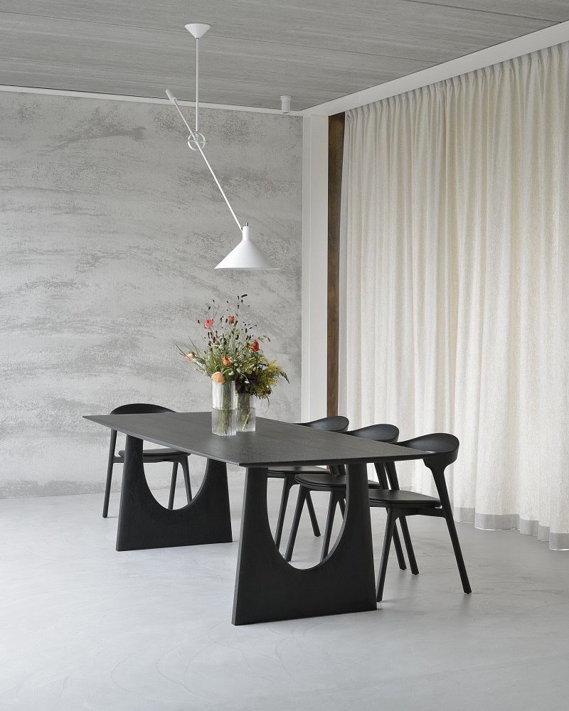 Ethnicraft Geometric Esstisch aus Eiche, schwarz, mit passenden Stühlen und Blumenvase in modernem Esszimmer.