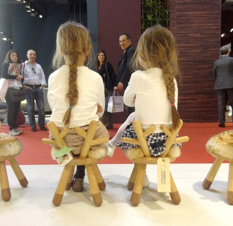 Zwei Mädchen sitzen auf Bambi Chair Kinderstühlen mit Geweih-Lehne und Fell-Sitzfläche.