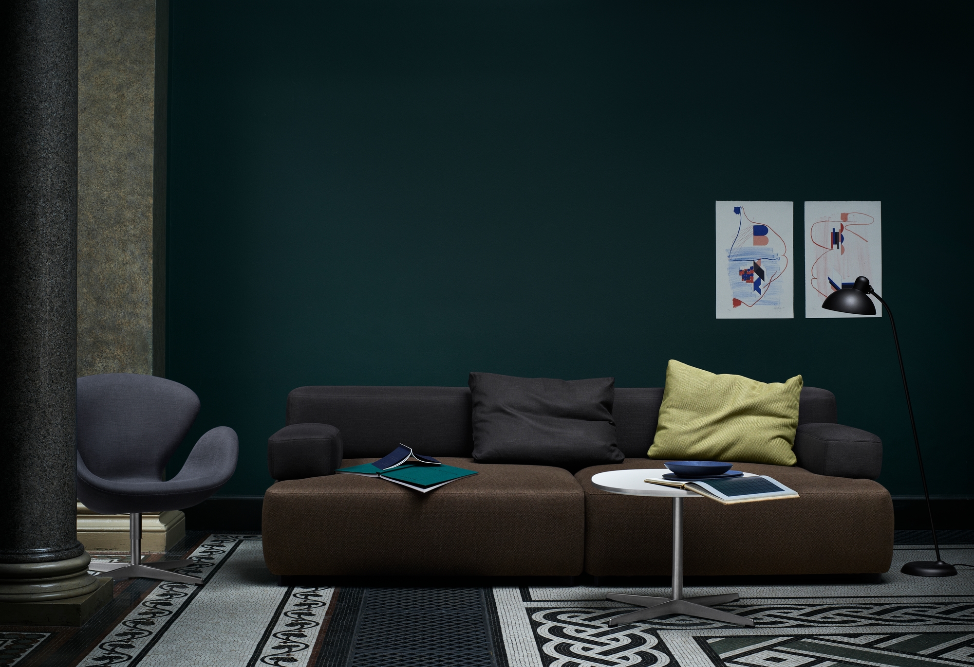 Wohnzimmer mit braunem Sofa, Sessel und Fritz Hansen Couchtisch, runde Form, weiß.