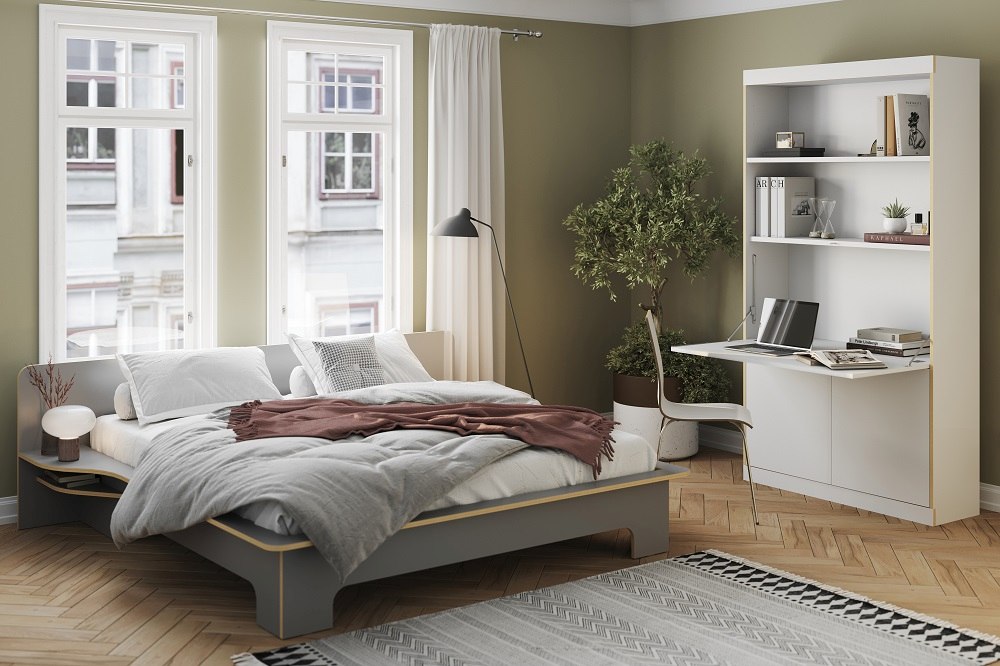 Modernes Schlafzimmer mit FLAI Home-Office Sekretär von Müller Möbelwerkstätten, Bett, Regal und Schreibtisch in Weiß.