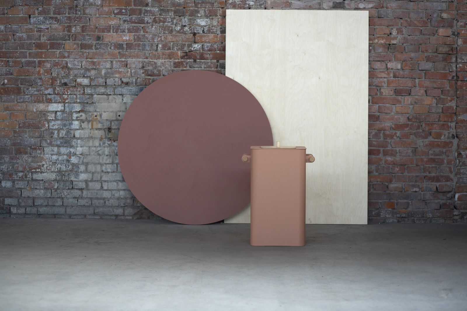 Arkiv Bin Mülleimer von Mizetto für die Mülltrennung, rosafarbener Design-Abfalleimer vor Backsteinwand und Holzplatte.