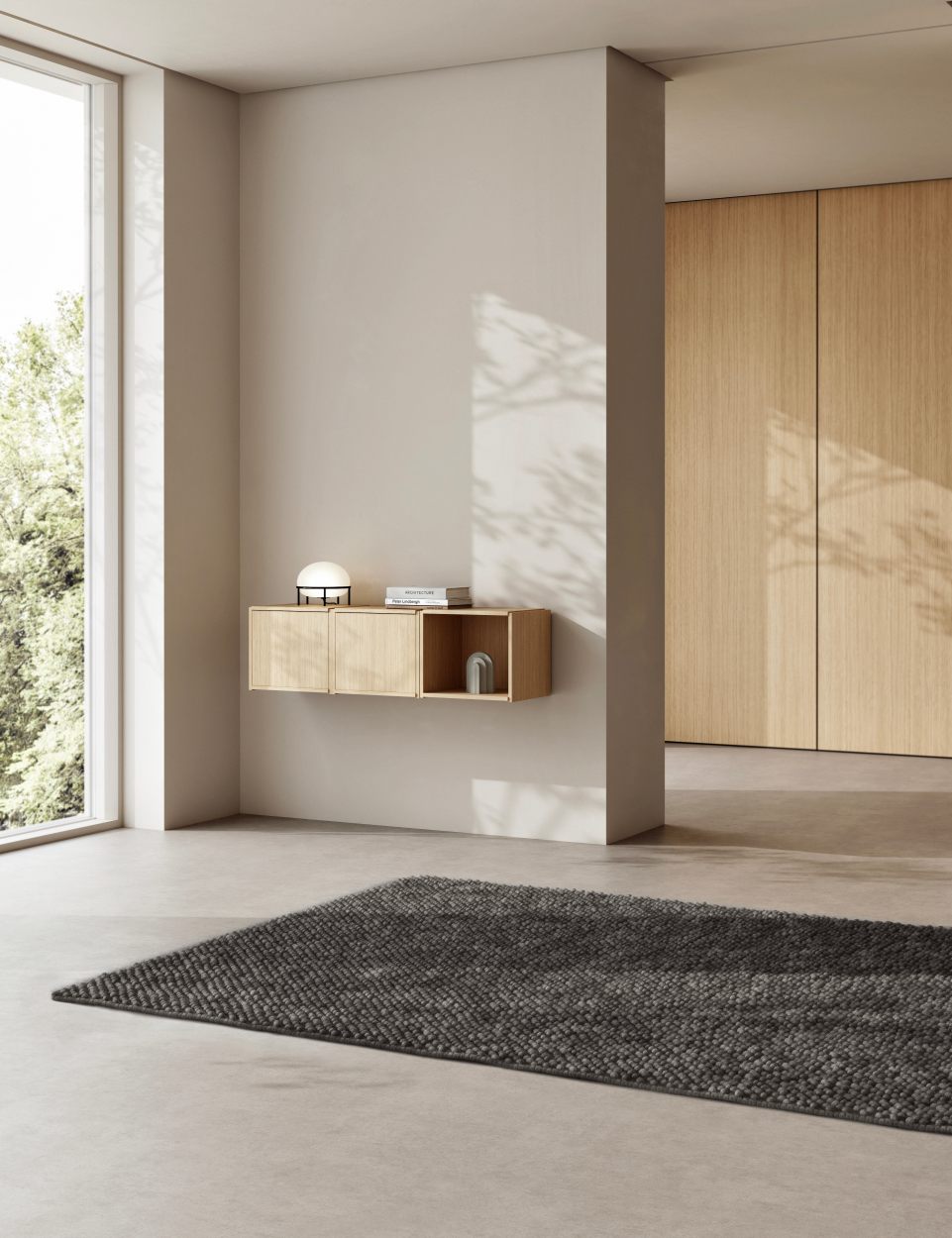 Helles Zimmer mit Woud Bricks System Regal aus Holz an der Wand.