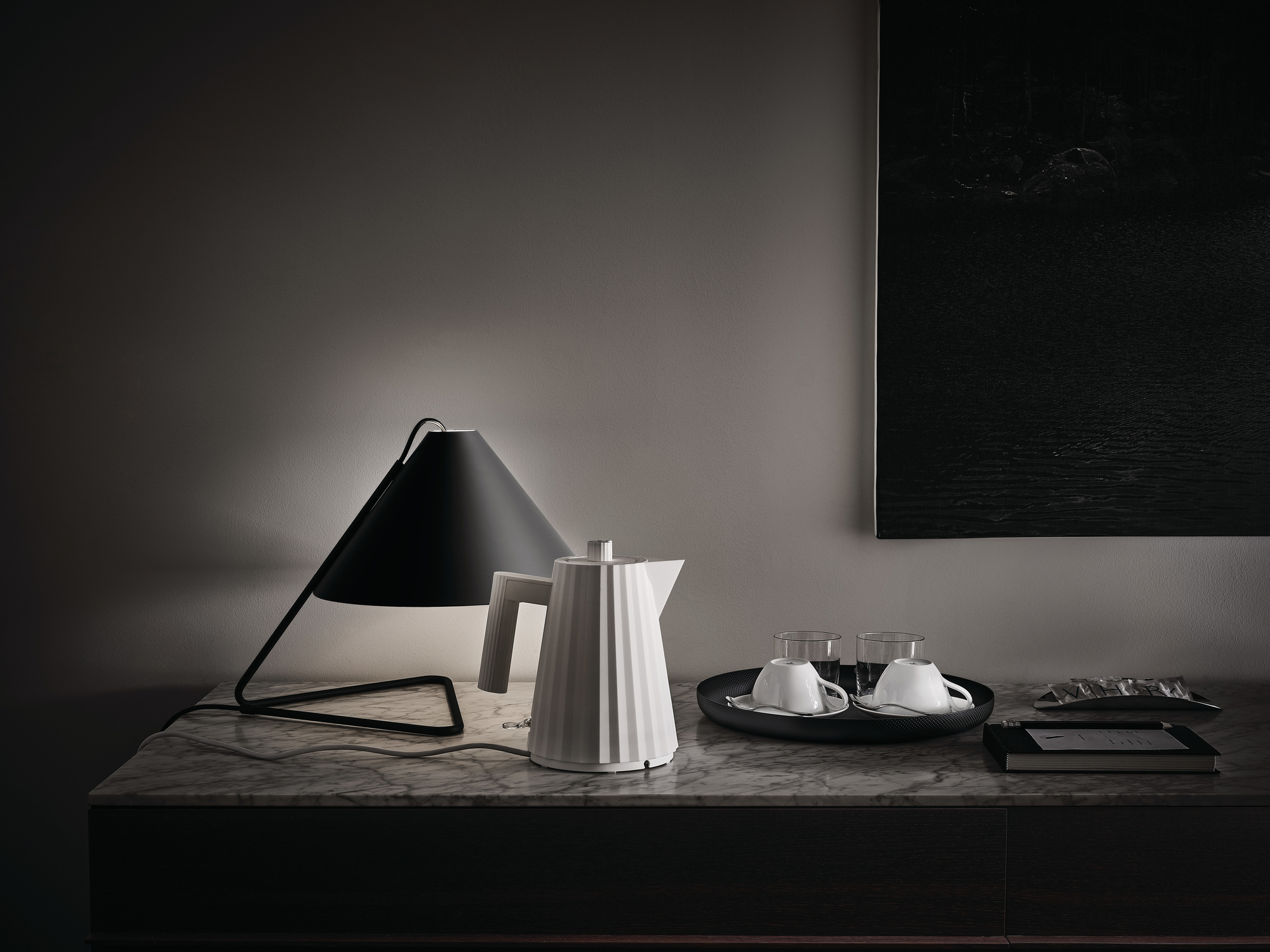 Weißer Alessi Plissé Wasserkocher auf Marmortisch mit Lampe und Tassen. Design Wasserkocher.