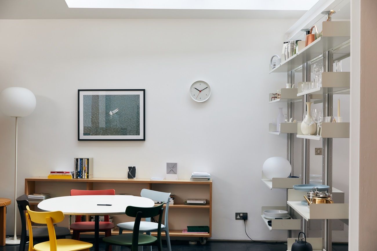 Helle, minimalistische Inneneinrichtung mit Hay Wanduhr, Esstisch und Regalsystem für stilvolles Wohnen.
