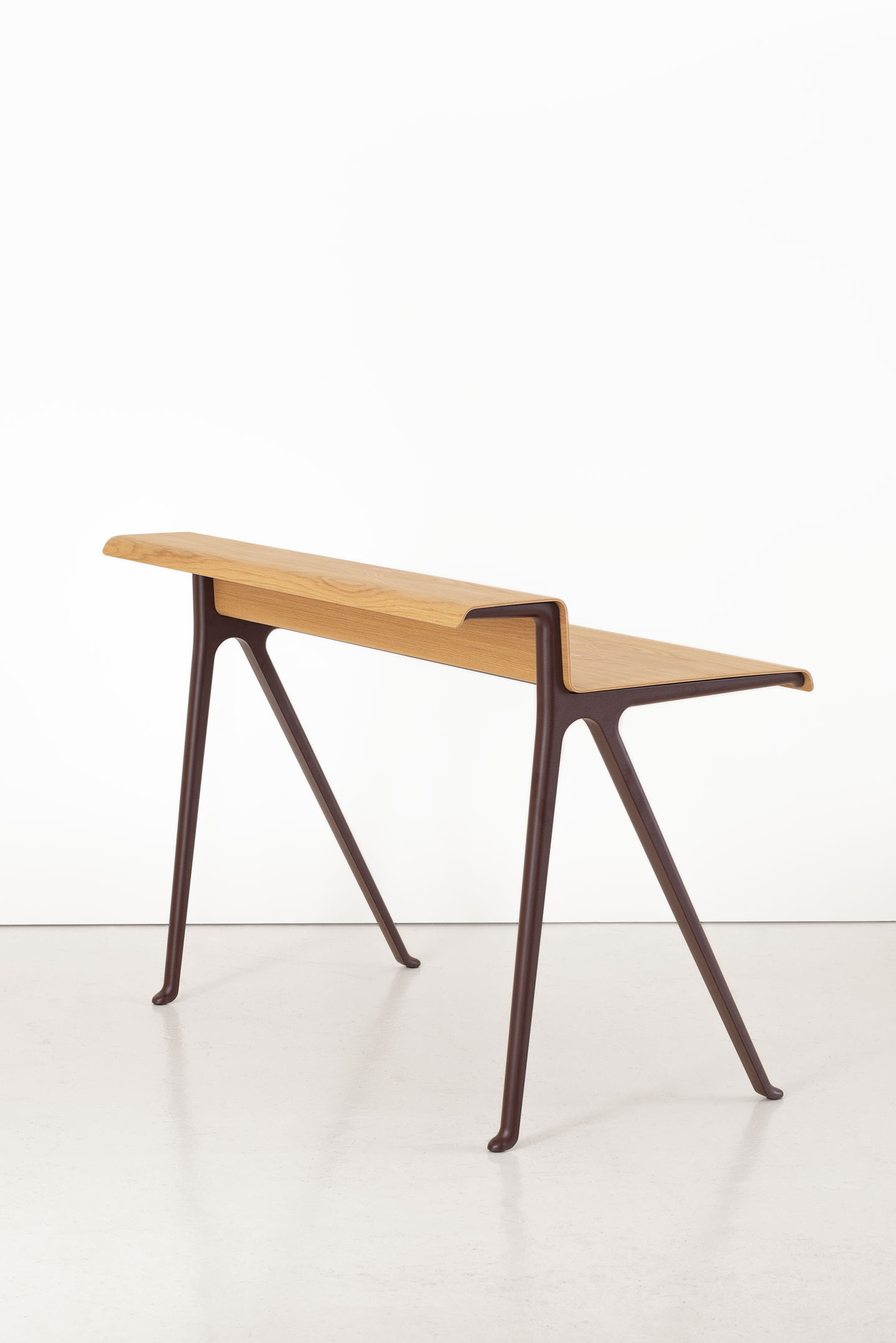 Vitra Courier Schreibtisch aus hellem Holz mit braunem Gestell vor weißem Hintergrund.