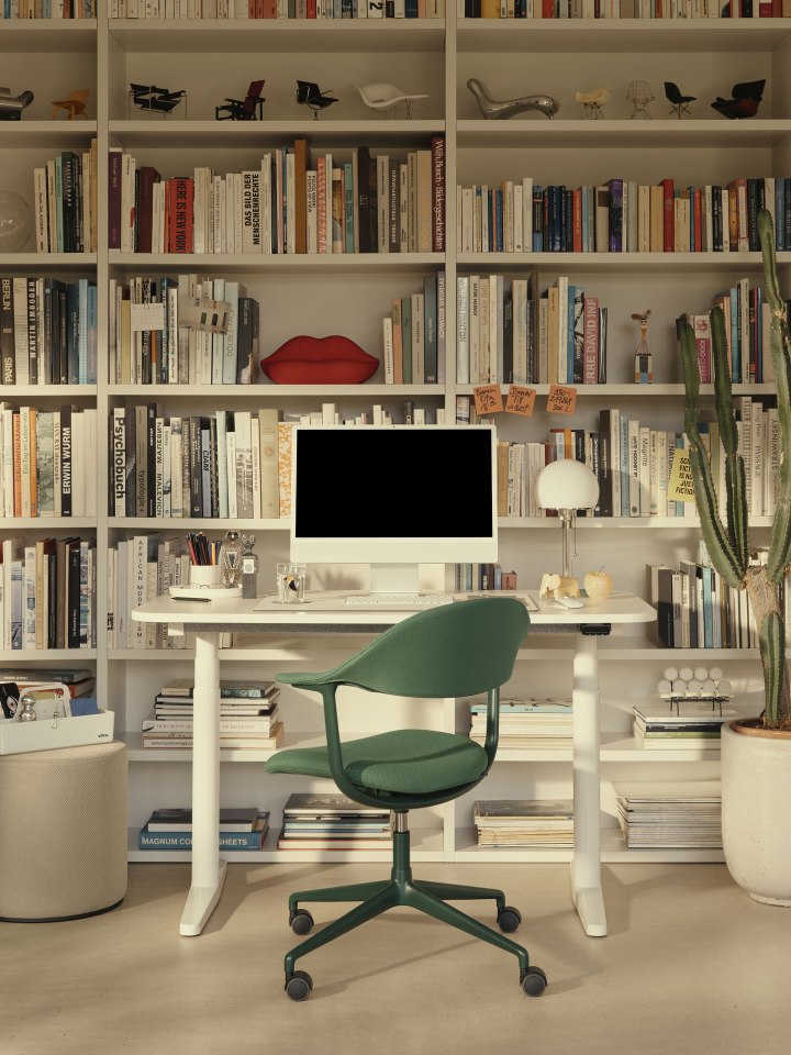 Mynt Bürodrehstuhl von Vitra mit grünem Bezug vor Bücherregal und Schreibtisch.