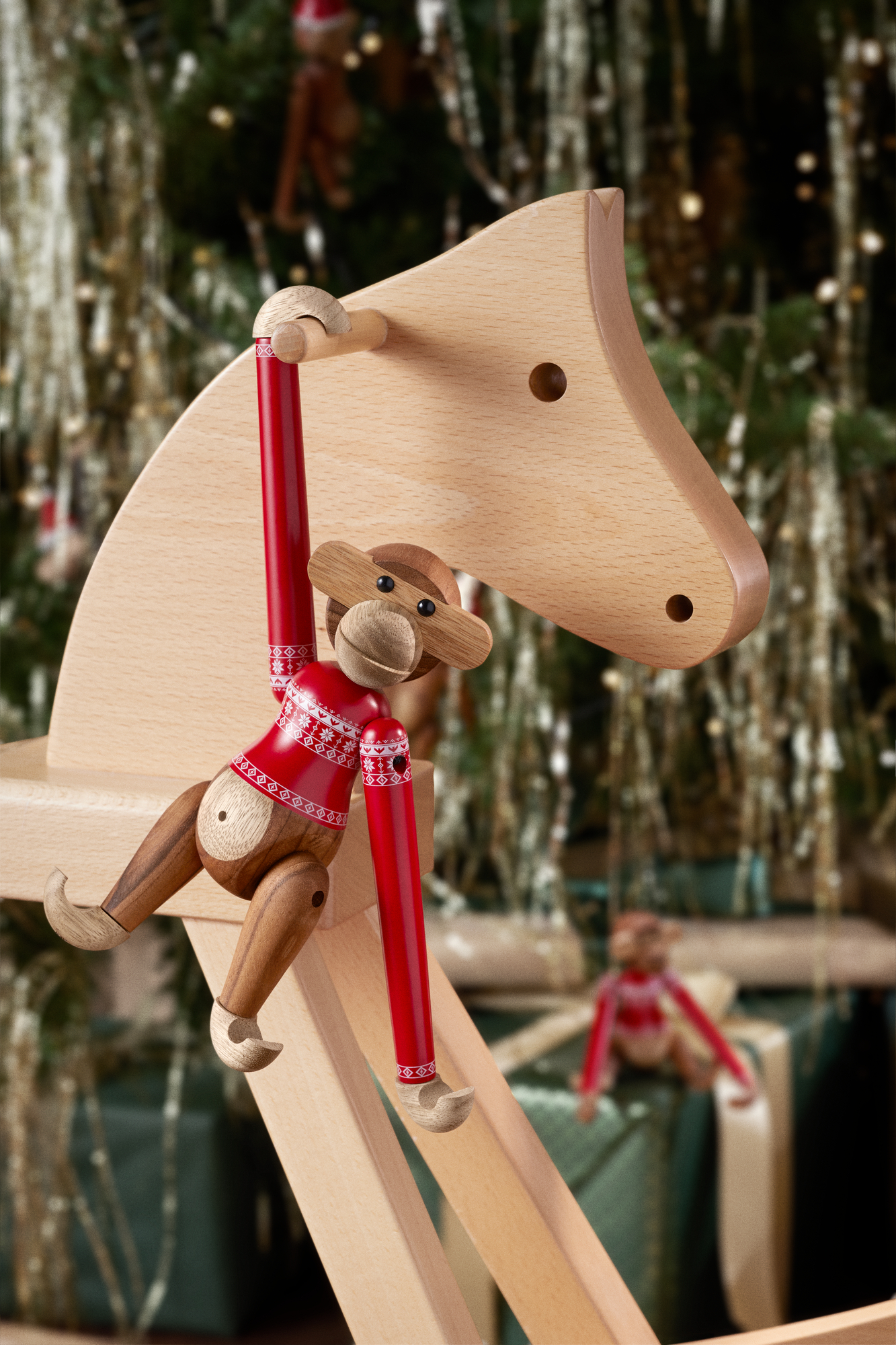Kay Bojesen Holzfigur Affe mit Weihnachtspullover auf Holzpferd, festliche Weihnachtsdekoration 2024.