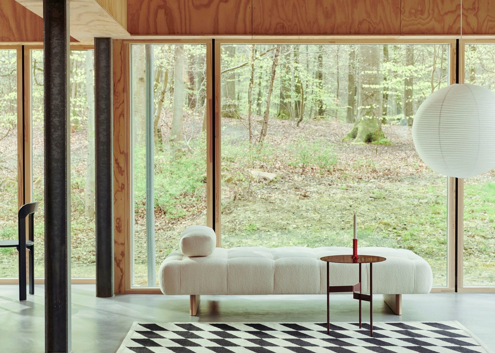 Helles Interieur mit Quilton Daybed Liege von Hay, Tisch und Teppich vor Fenster.