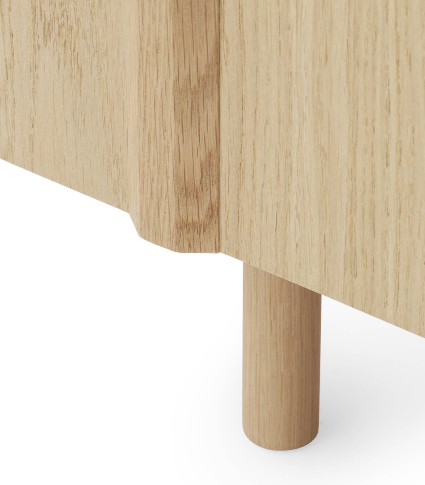 Detailaufnahme des Normann Copenhagen Rib Sideboards aus Eichenholz, Fokus auf Bein und gerippte Seitenstruktur.