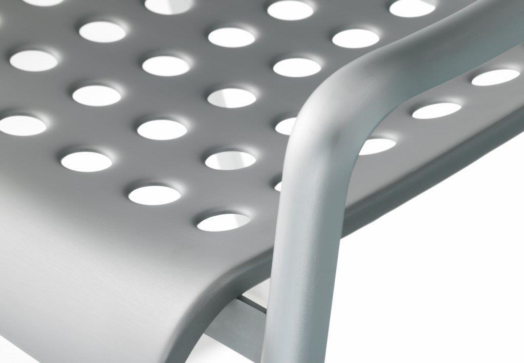 Detailaufnahme des Landi Stuhls von Vitra, Sitzfläche aus Aluminium mit charakteristischen Lochmuster und Armlehne.