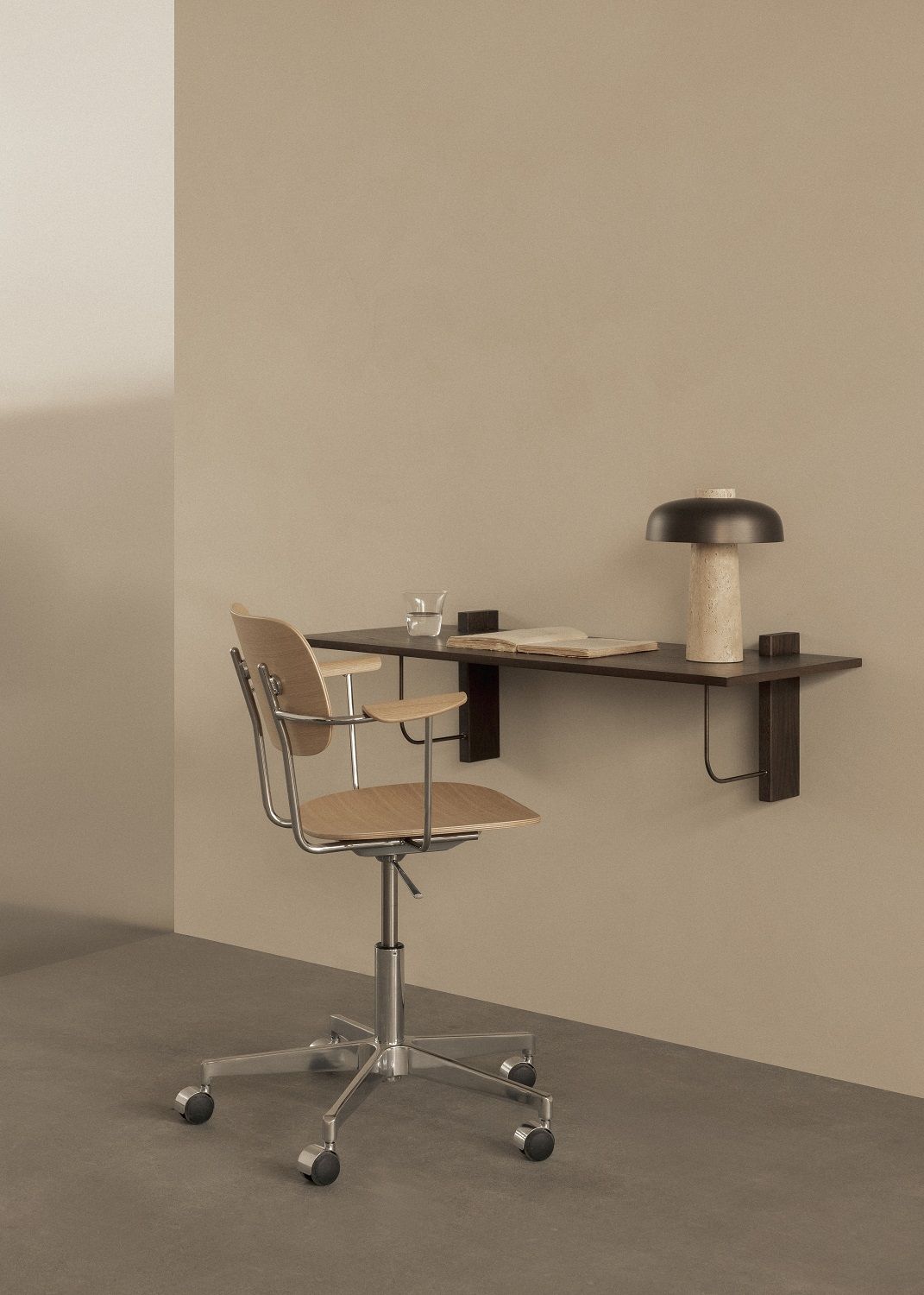 Audo Copenhagen Co Task Chair Bürostuhl mit Holzschale und Rollen vor Wandtisch.