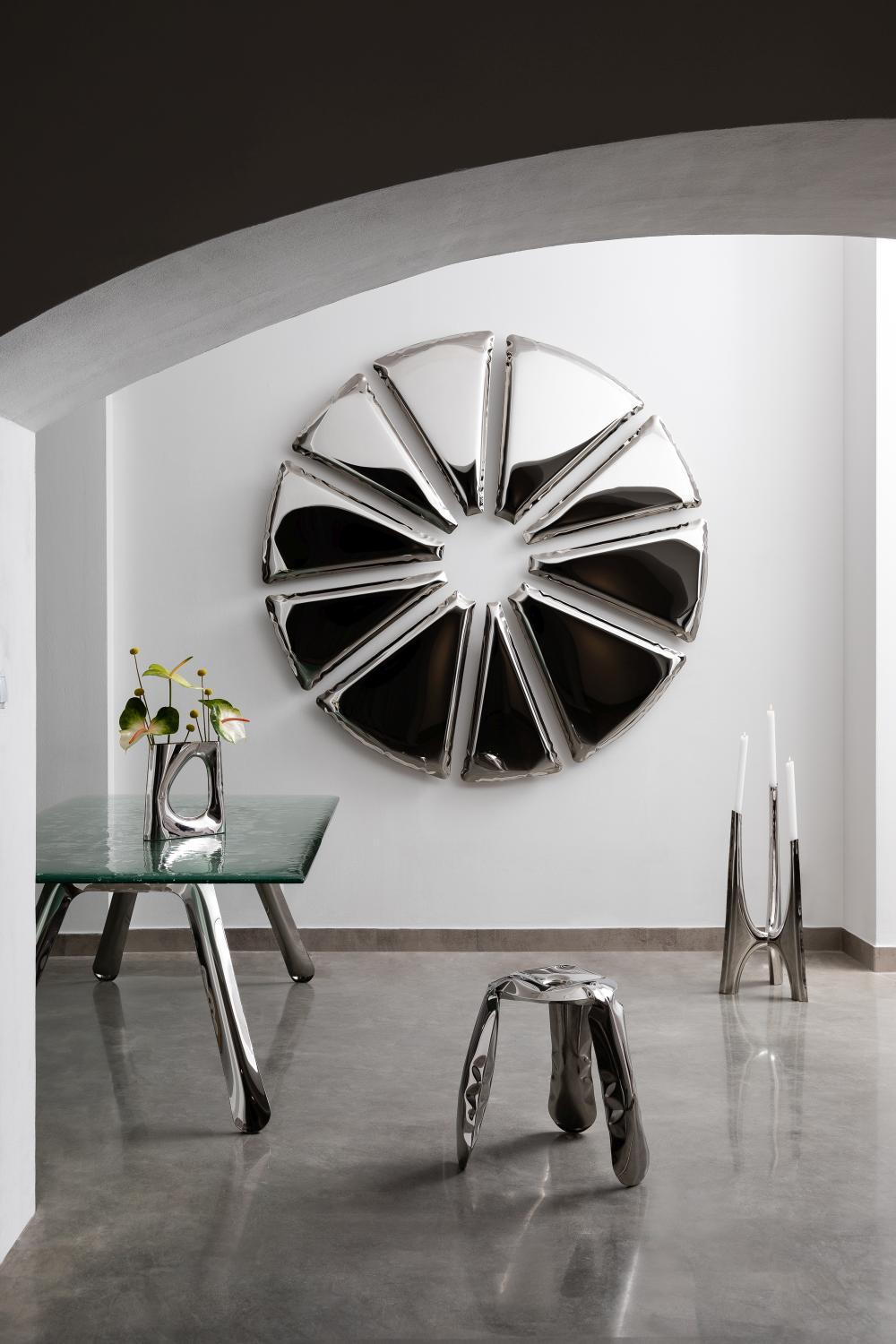 Nucleus Spiegel von Zieta, ein runder, silberner Design-Spiegel an einer weißen Wand.