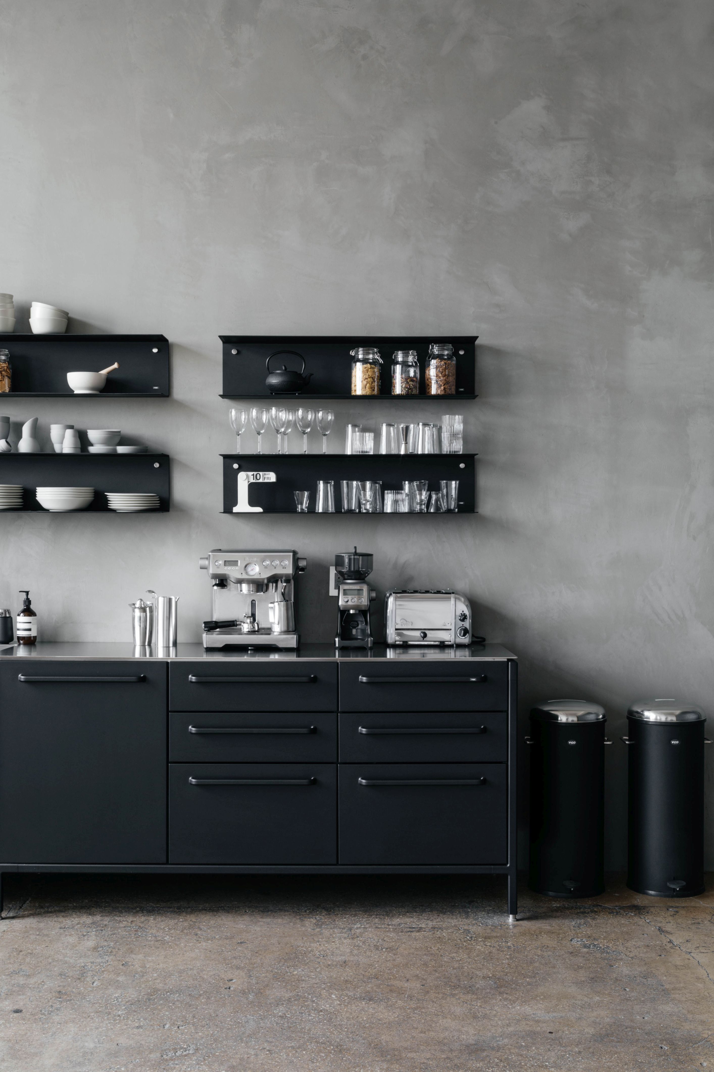Zwei schwarze Vipp Treteimer 30 Liter mit Edelstahldeckel in moderner Küche neben schwarzem Sideboard.
