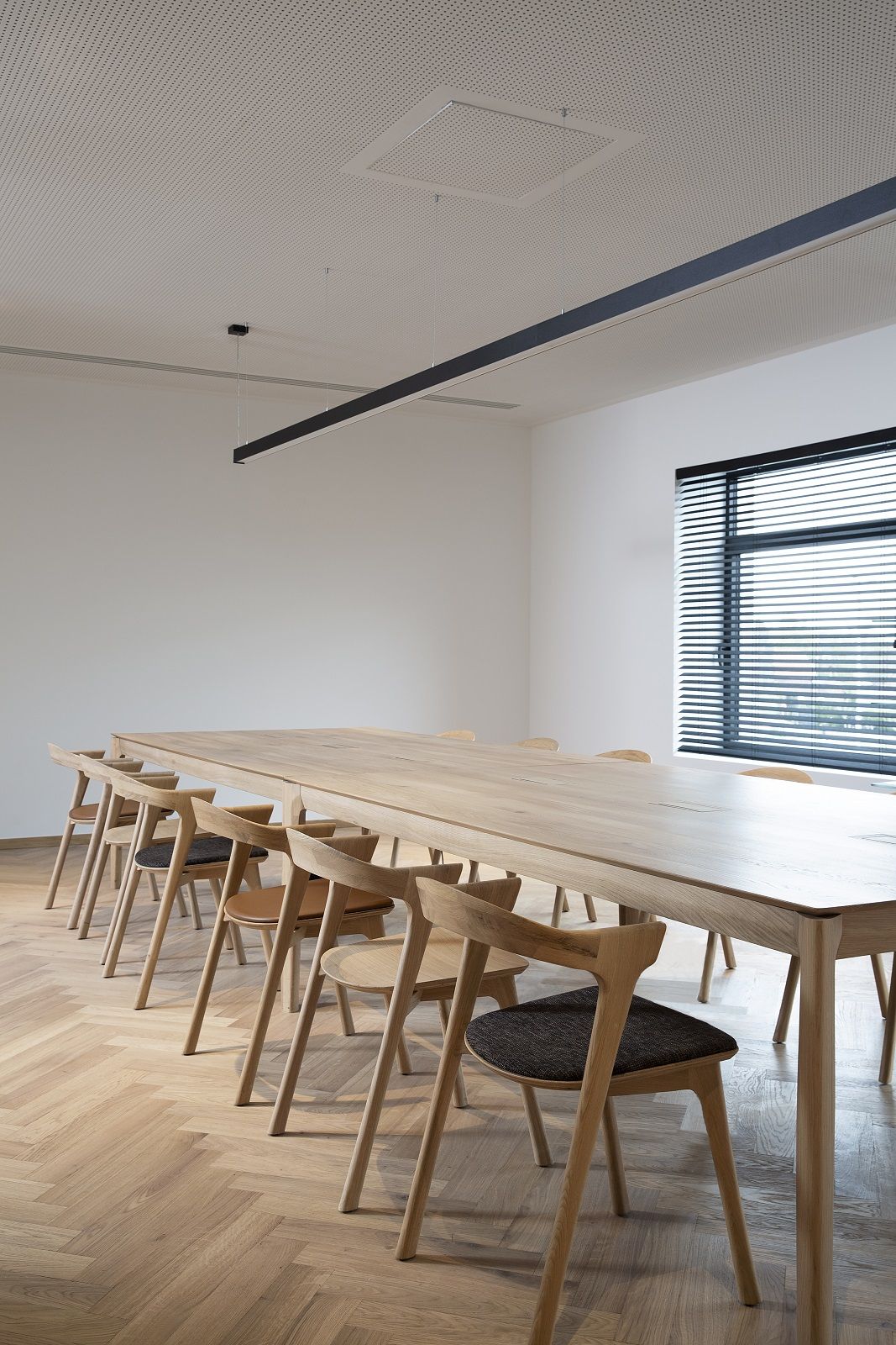 Bok Cowork Schreibtisch von Ethnicraft aus Eiche mit Stühlen in einem hellen, modernen Büro.