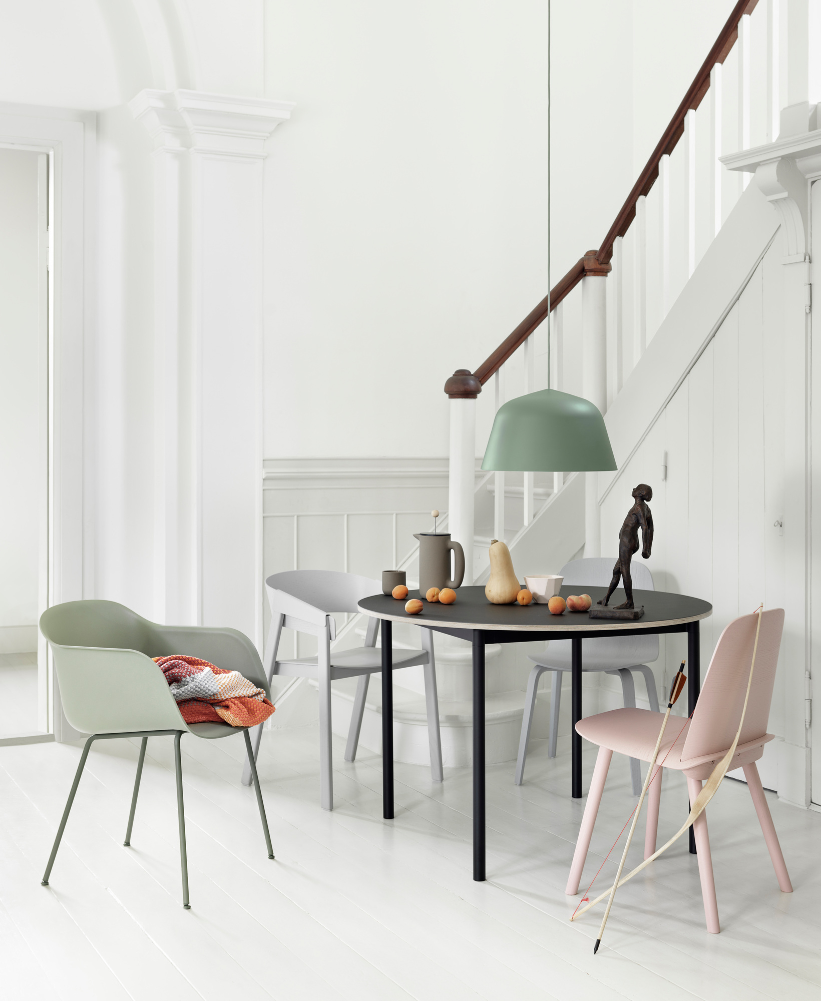 Esszimmer mit Muuto Fiber Armchair und weiteren Stühlen um einen runden Tisch. Modernes Möbeldesign.