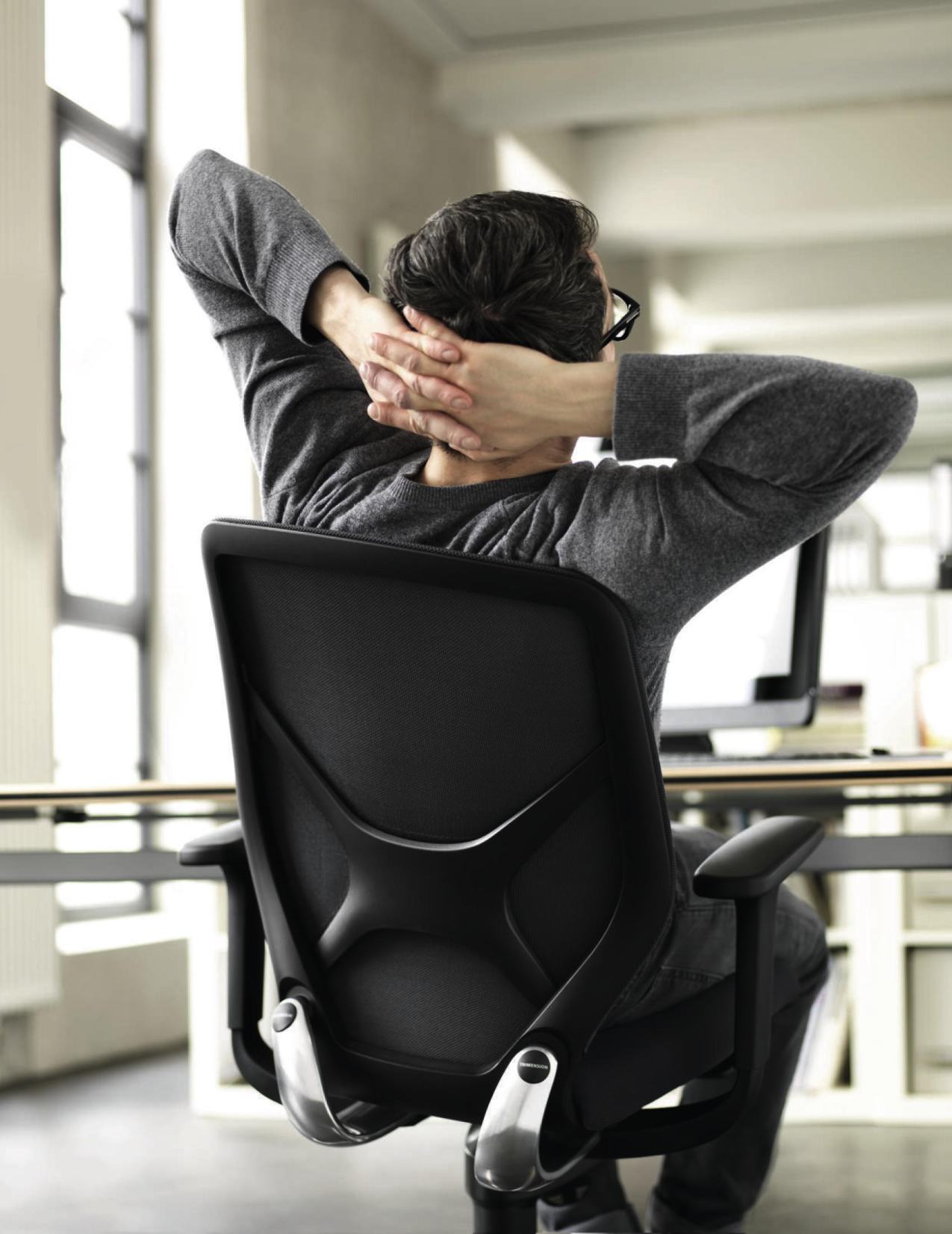 Mann entspannt auf ergonomischem Bürostuhl mit Armlehnen und atmungsaktiver Rückenlehne im modernen Büro.