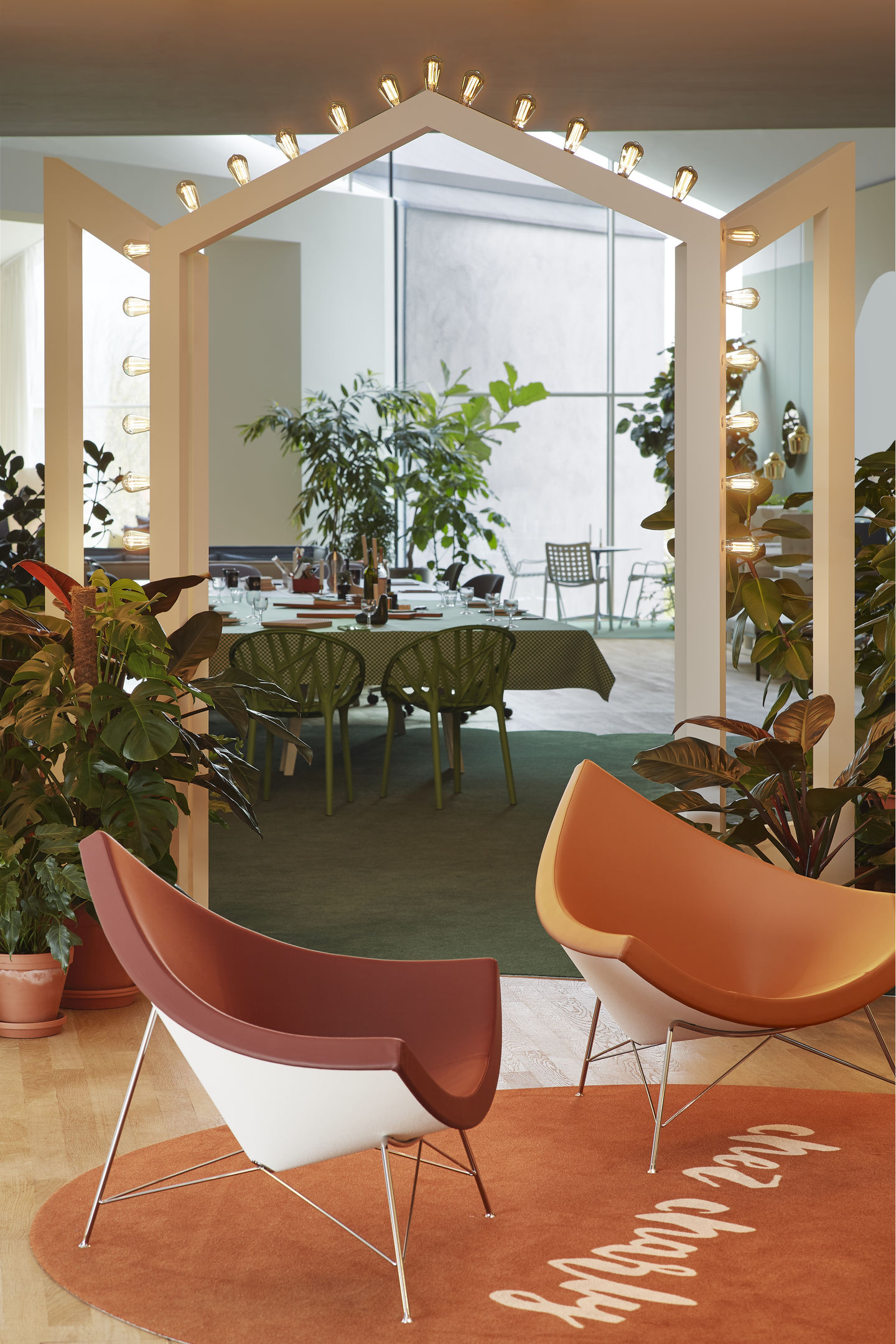Zwei Coconut Chairs von Vitra in einem stilvollen Wohnzimmer mit Pflanzen und Esstisch.