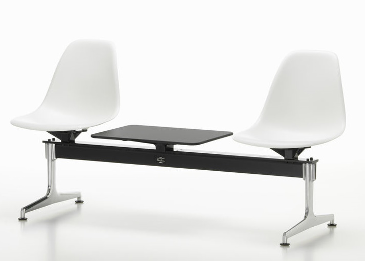 Eames Plastic Side Chair RE auf Traverse von Vitra mit weißen Sitzschalen und schwarzem Tisch.