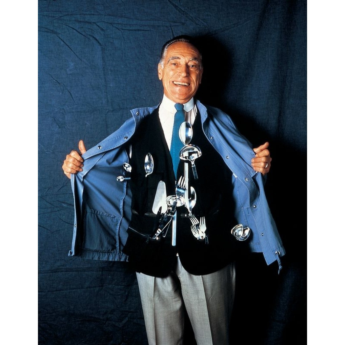 Mann mit Jacke voller Alessi Dry Besteck, humorvolle Produktpräsentation für das 30-teilige Besteckset.