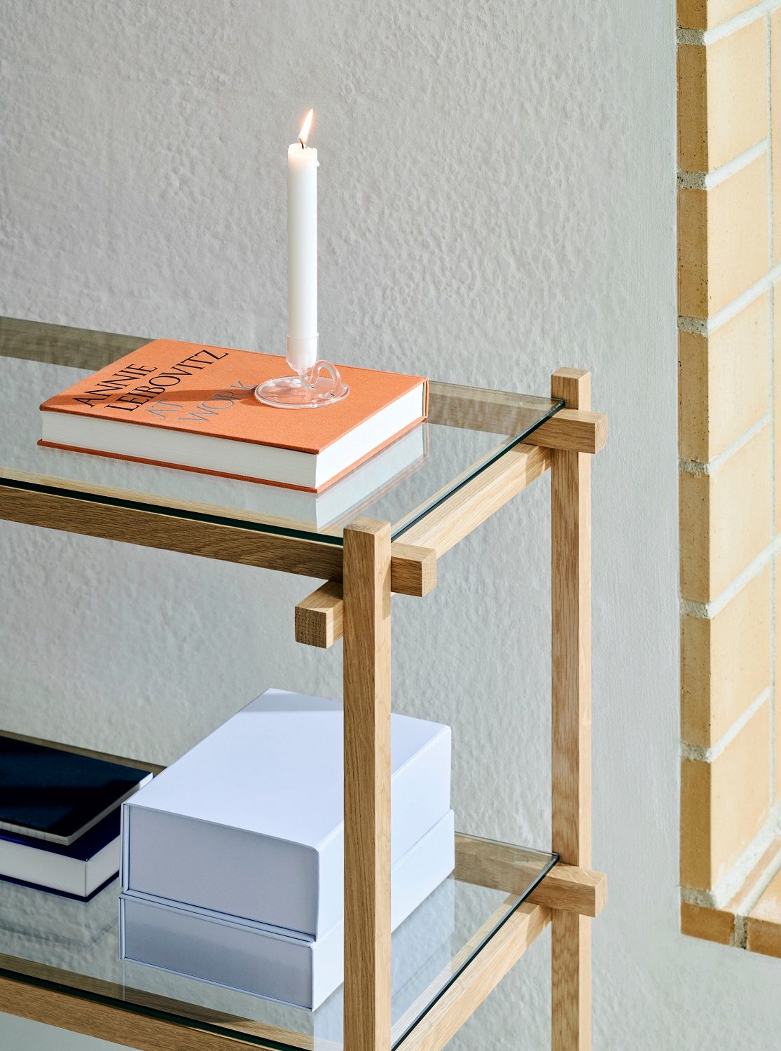 Helles Woody Column Low Regal von Hay mit Glasböden, dekoriert mit Buch, Kerze und Boxen.