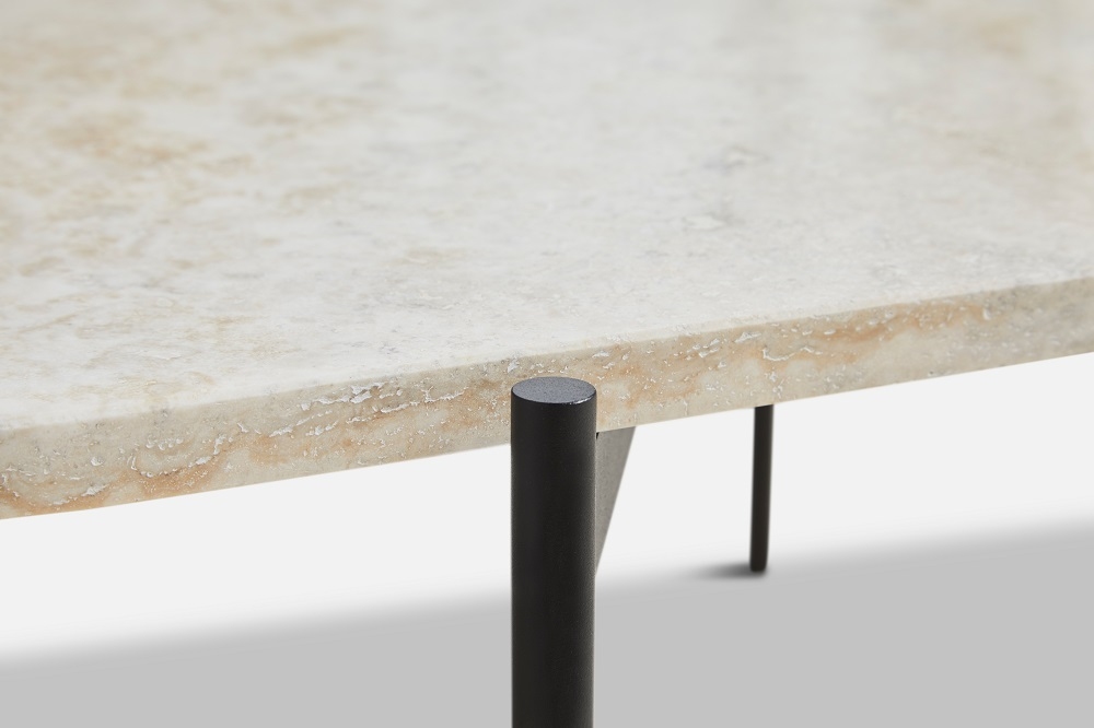 Detailaufnahme des La Terra Couchtischs von Woud mit Travertinplatte und schwarzen Metallbeinen.