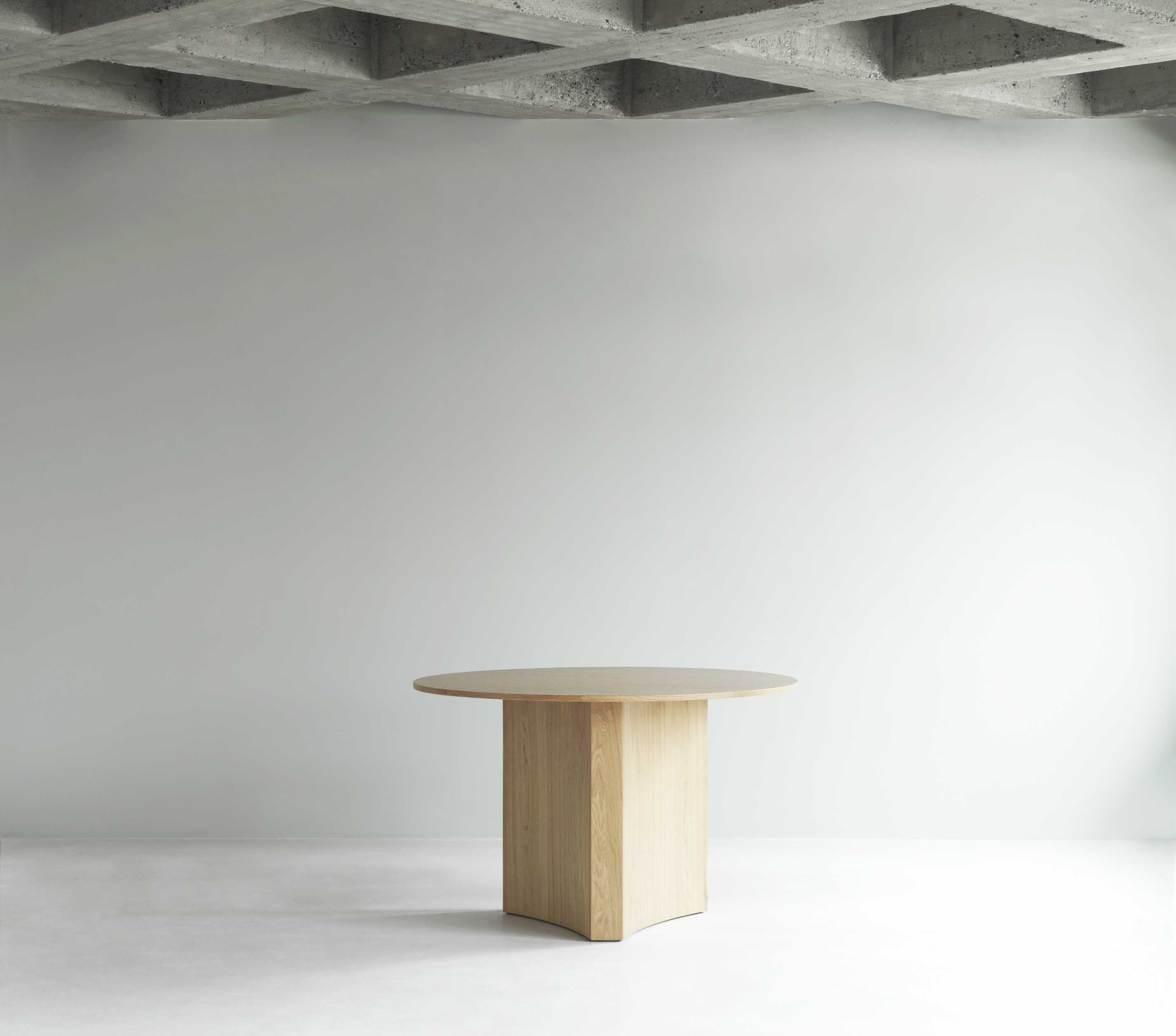 Runder Bue Table Esstisch von Normann Copenhagen aus hellem Holz vor weißer Wand.
