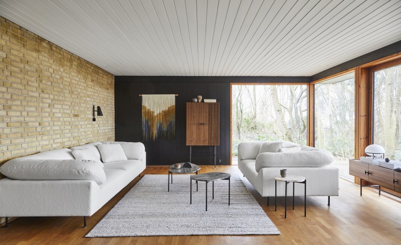 Wohnzimmer mit hellem Tact Rug Teppich von Woud (200x300 cm) und weißen Sofas.