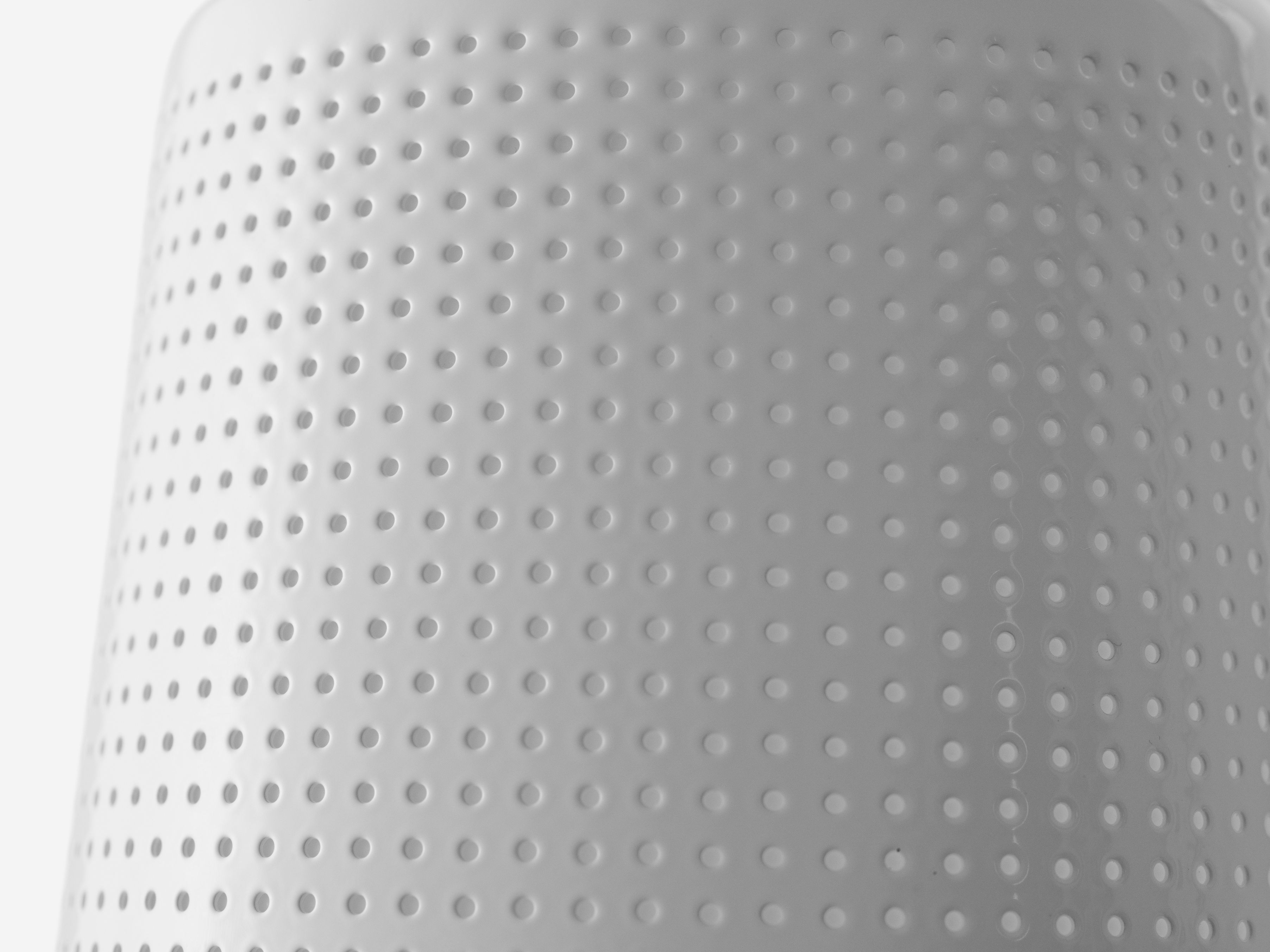 Detailaufnahme der weißen Vipp Wandspot Lampe mit charakteristischem, perforiertem Lampenschirm für indirekte Beleuchtung.