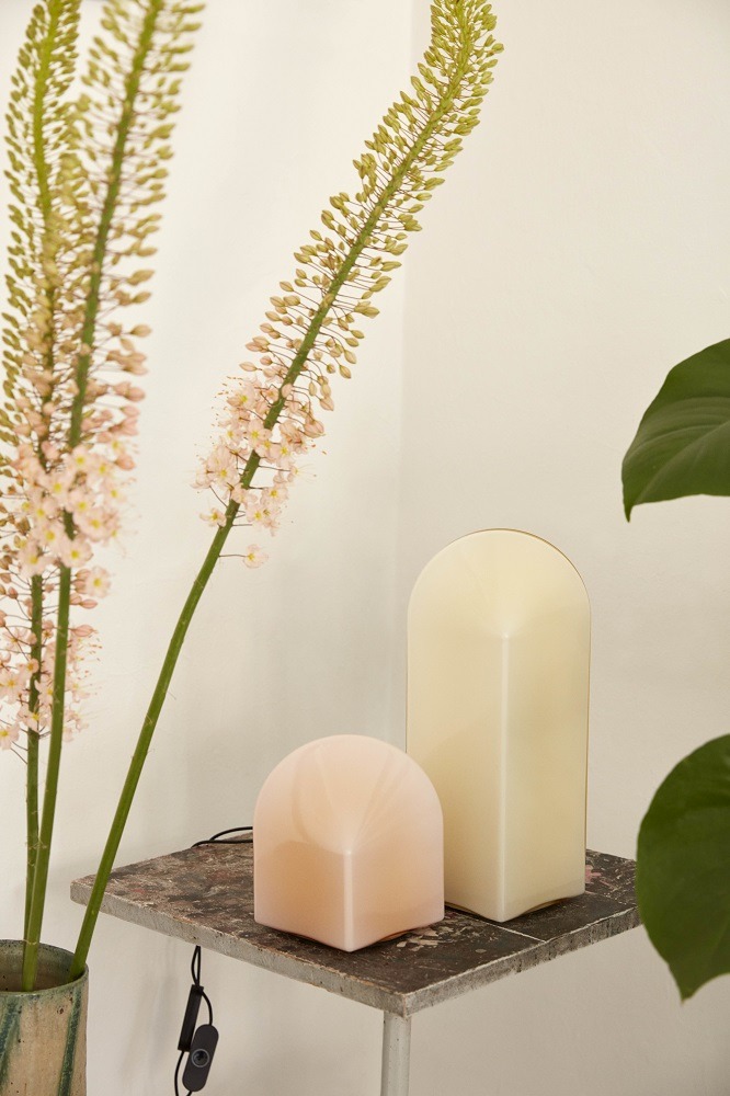 Zwei Hay Parade Table Lamp Tischleuchten in Beige und Rosa auf einem Regal mit Dekoration.