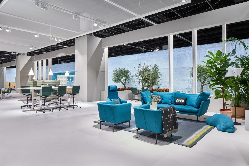 Helles Interieur mit blauem Suita Sofa, Sesseln und Pflanzen. Designermöbel für Wohnzimmer und Büro.
