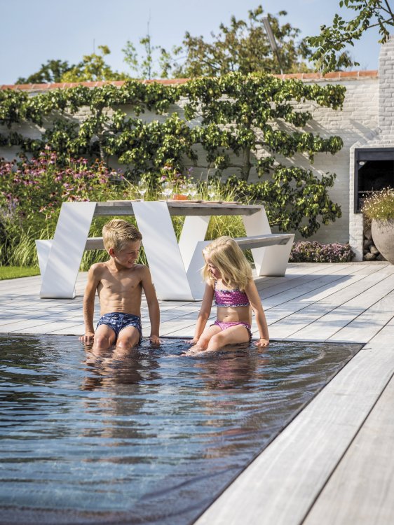 Hopper Picknickbank von Extremis im Garten mit spielenden Kindern am Pool.